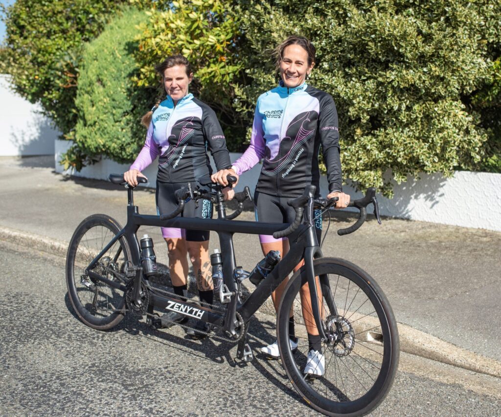 Hannah and Kara proudly stand behind their tandem bike.