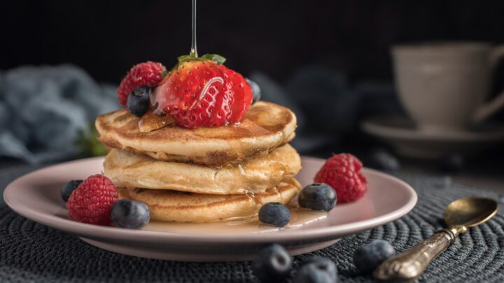 Protein pancakes topped with strawberries, blueberries and maple syrup