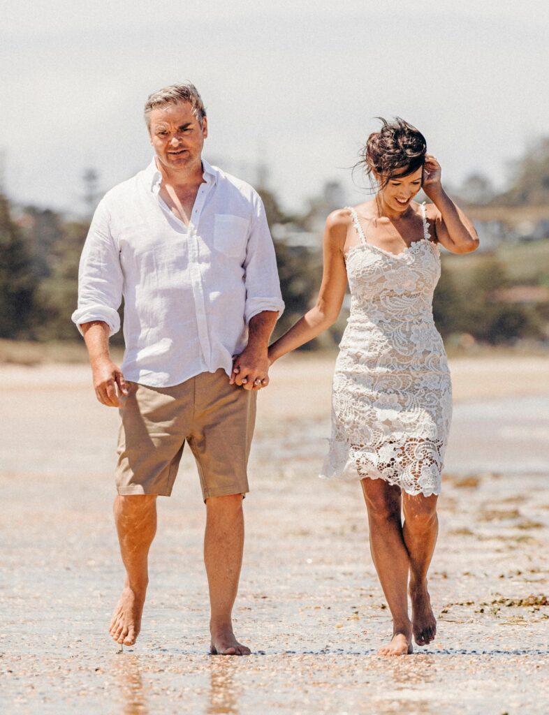 Andrew Saville and Helen Castles walkdown the beach on their wedding day