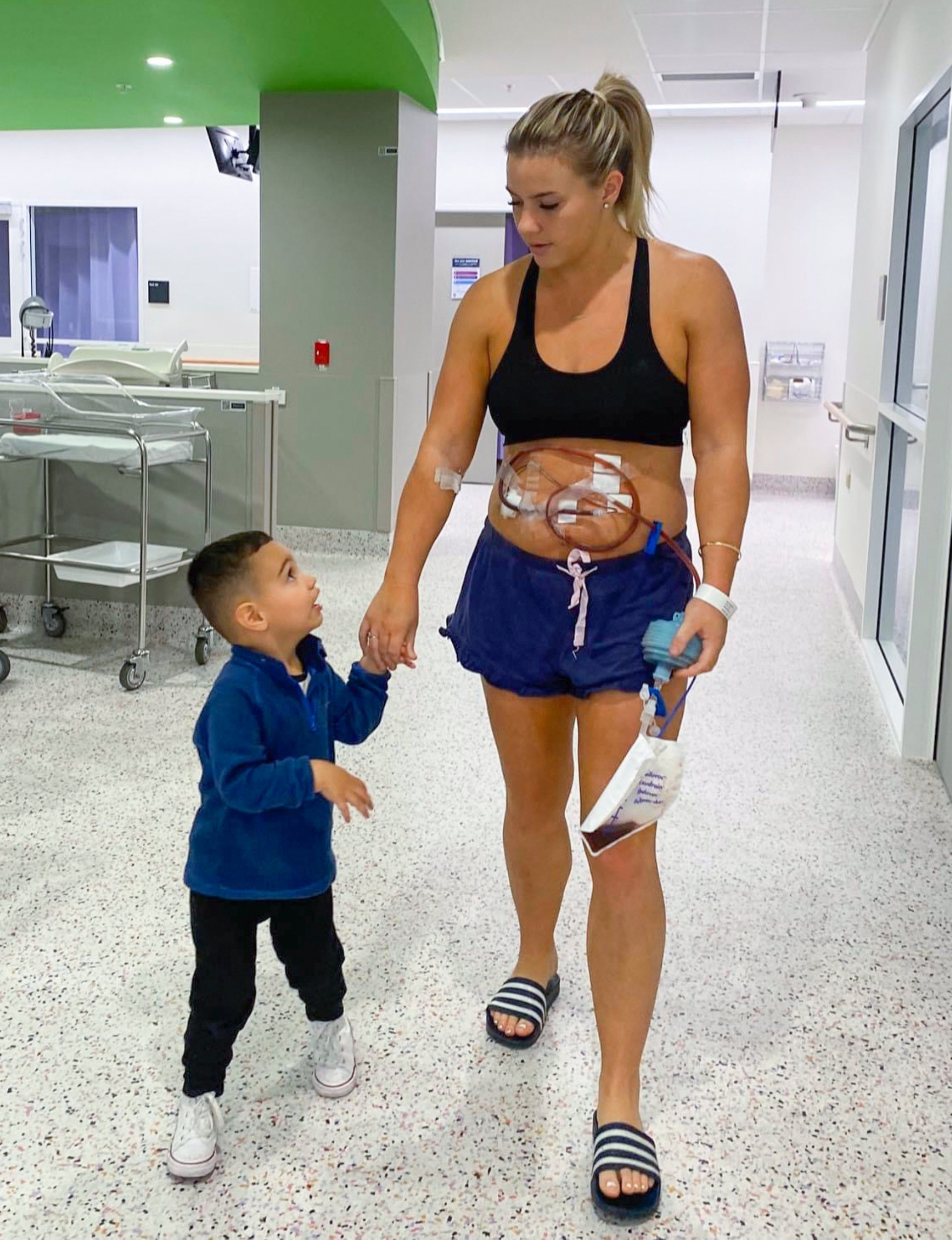 Nikki Johns walking through the hospital because of her colitis again, holding her son's hand
