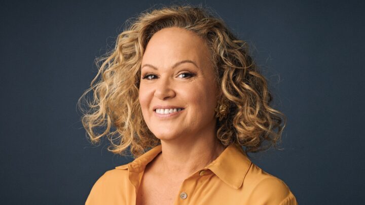 Leah Purcell in a yellow top in front of a black background