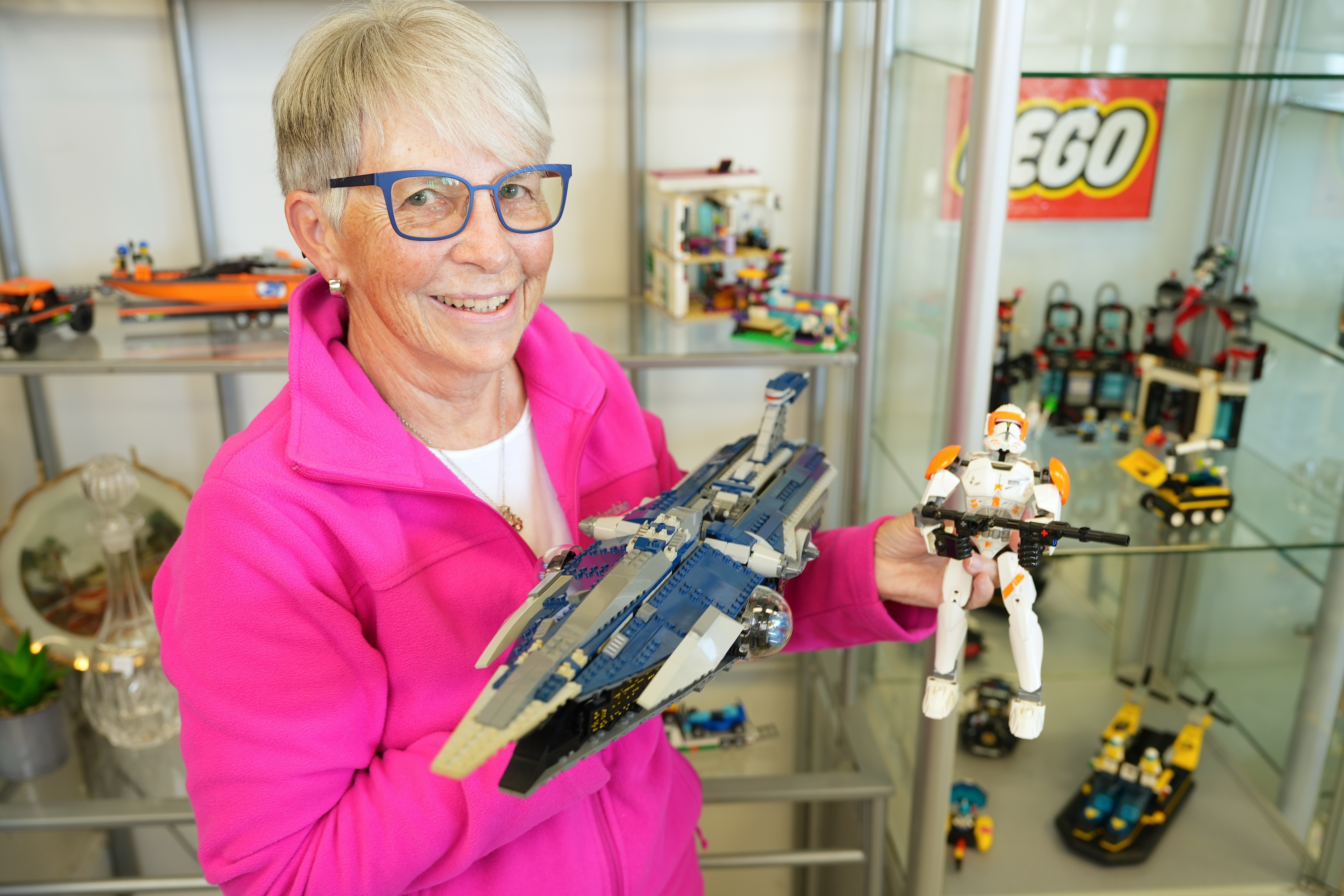 Val holding up some of the Lego structures she has built during her retirement