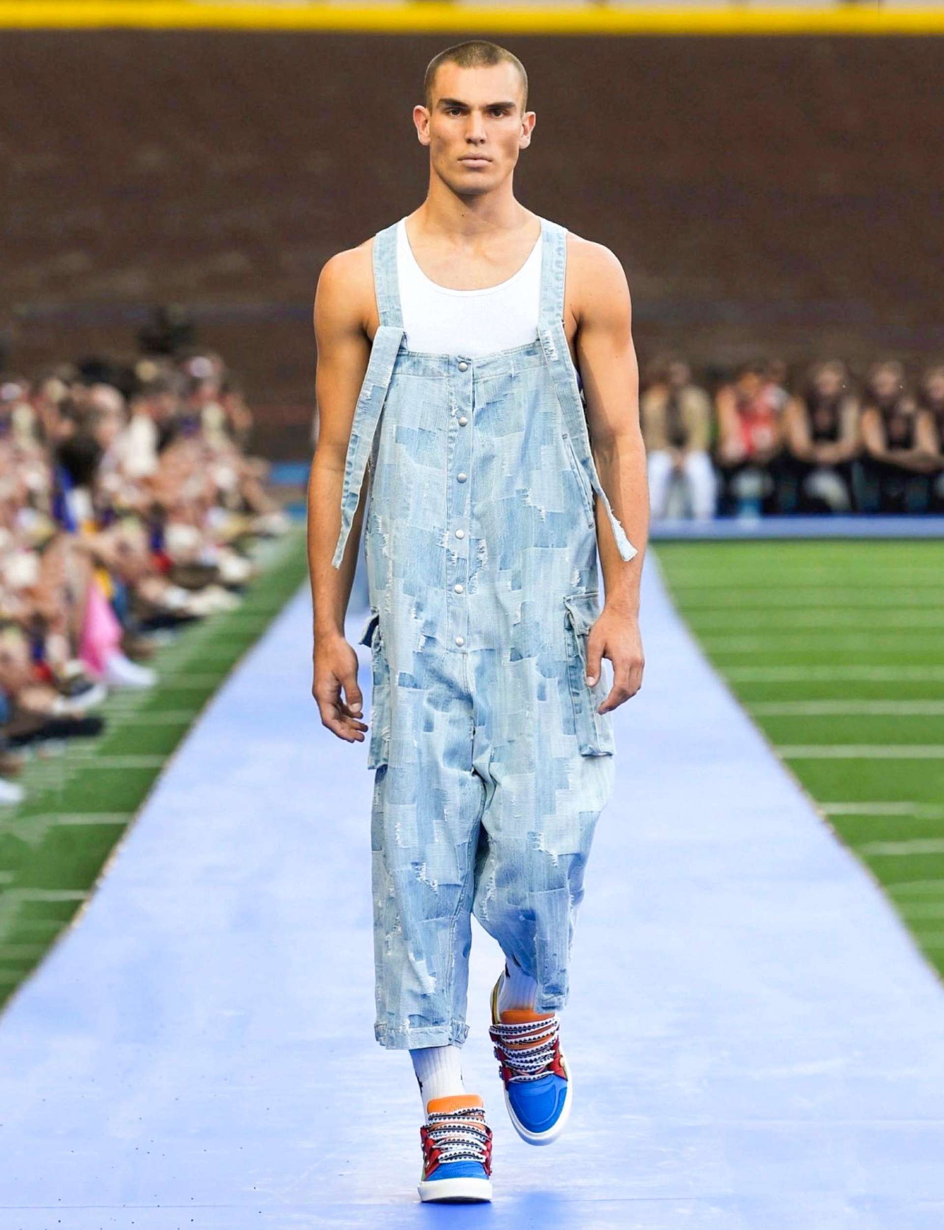 Josh walking down the runway in denim  patched overalls