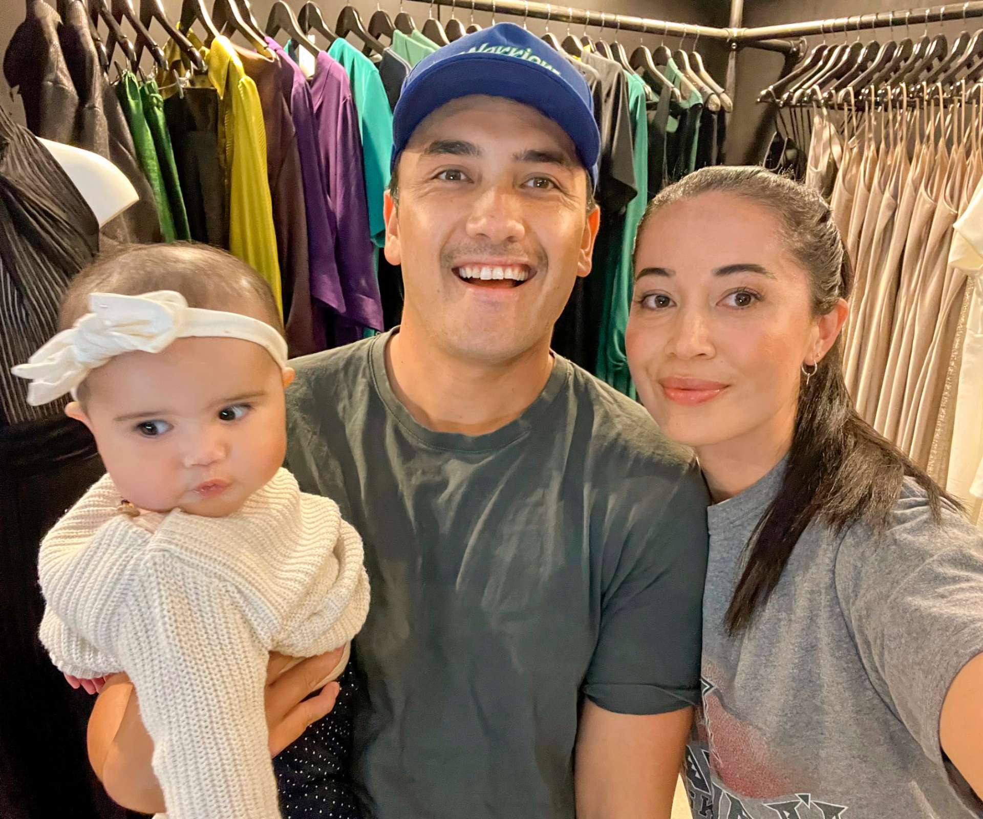 Kiri's son Astley with his daughter Mahina and partner Kim in front of a rack of clothes