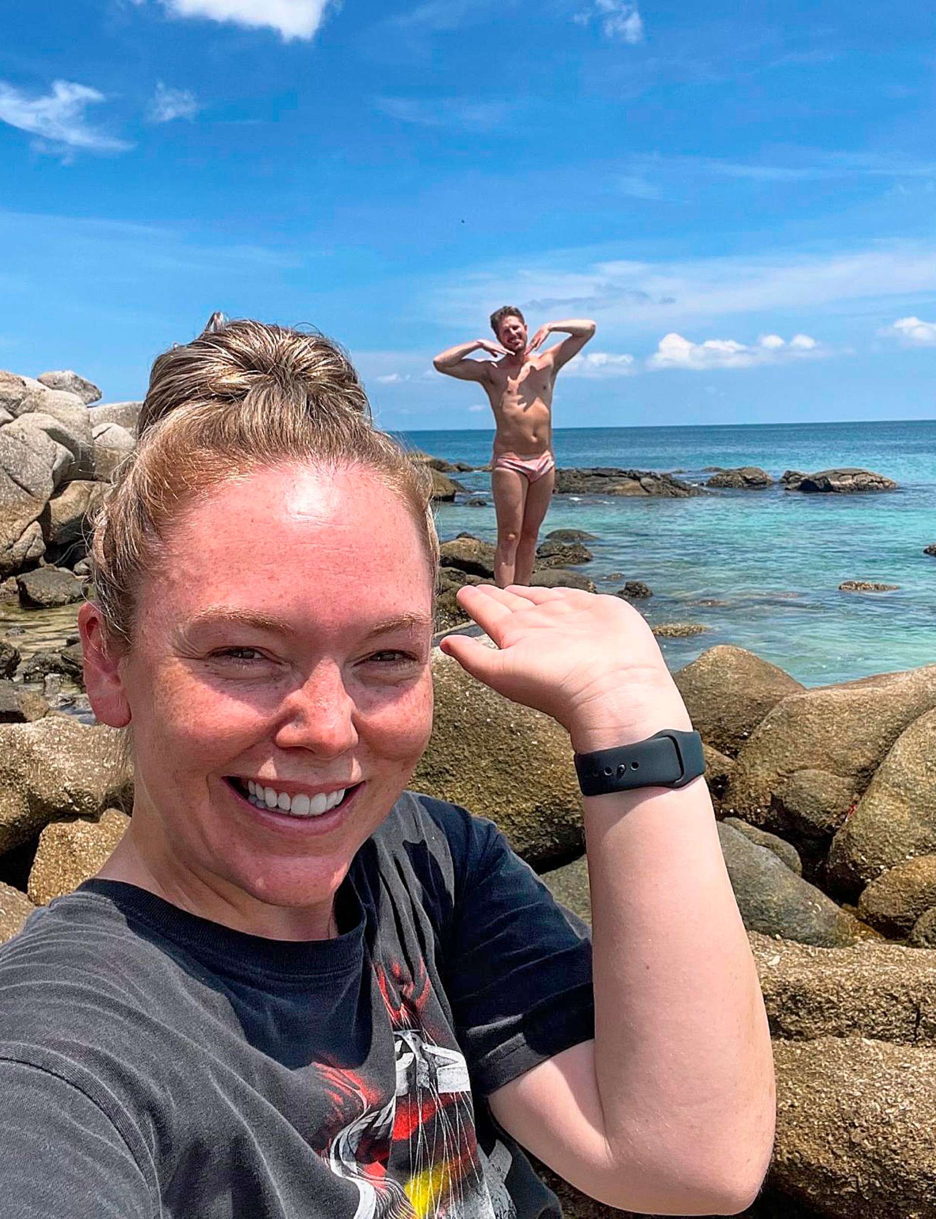 Melissa standing in the front of her photo, holding her hand up flat. Bryce is in Speedos standing on a rock behind Melissa, made to look like he's standing in her hand