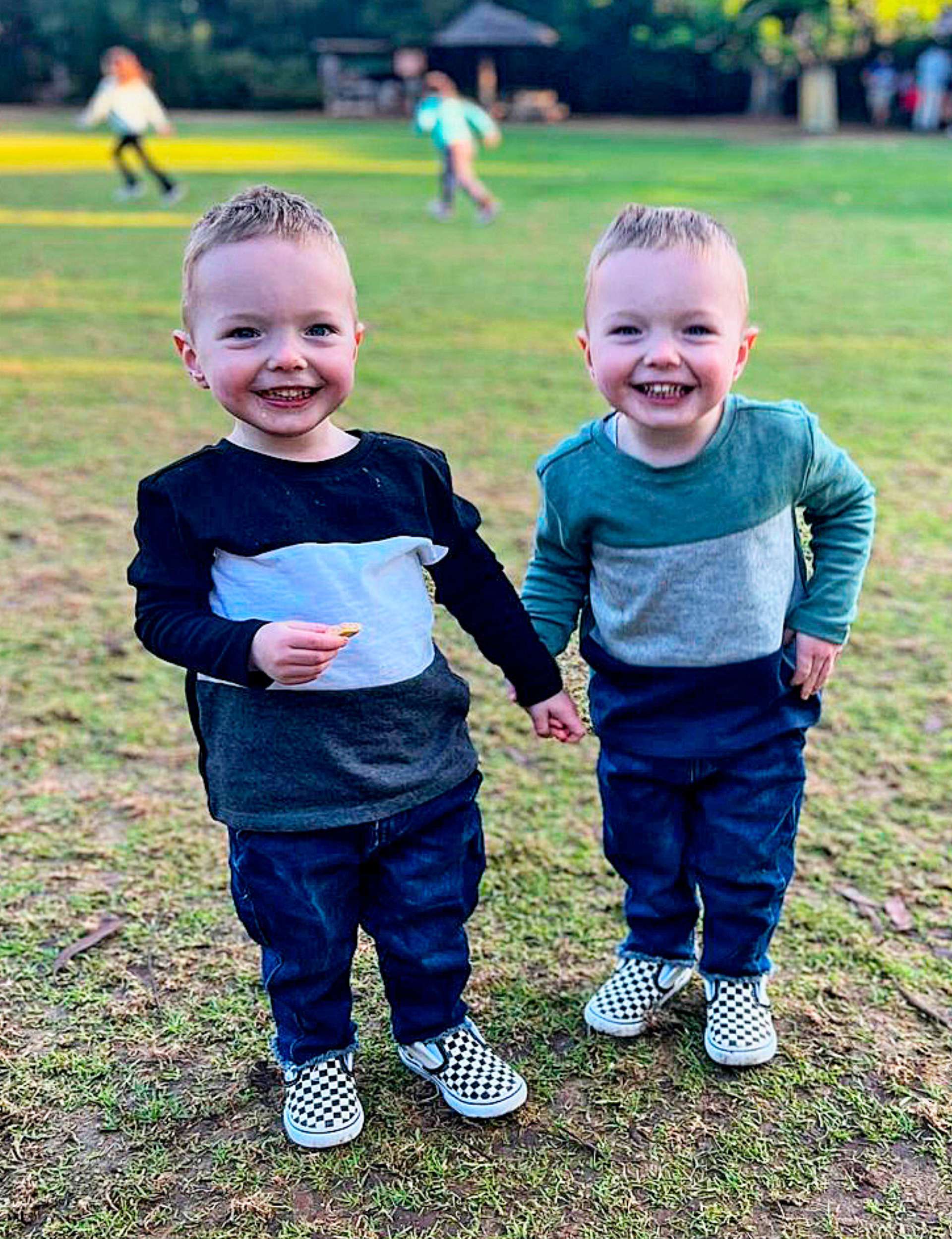 Bryce and Melissa's twin sons holding hands and giggling