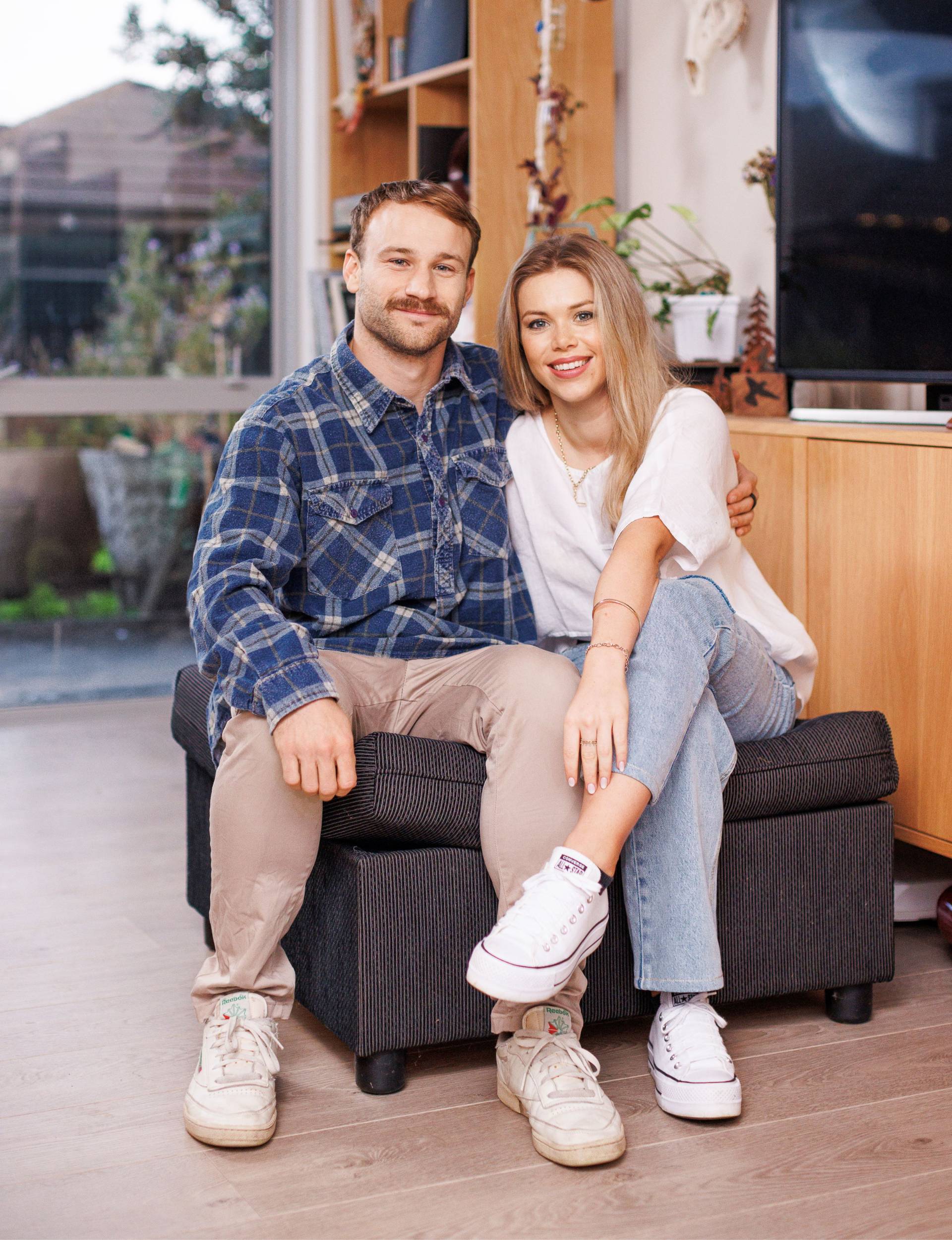 Dylan and Maddie sitting together on an ottoman