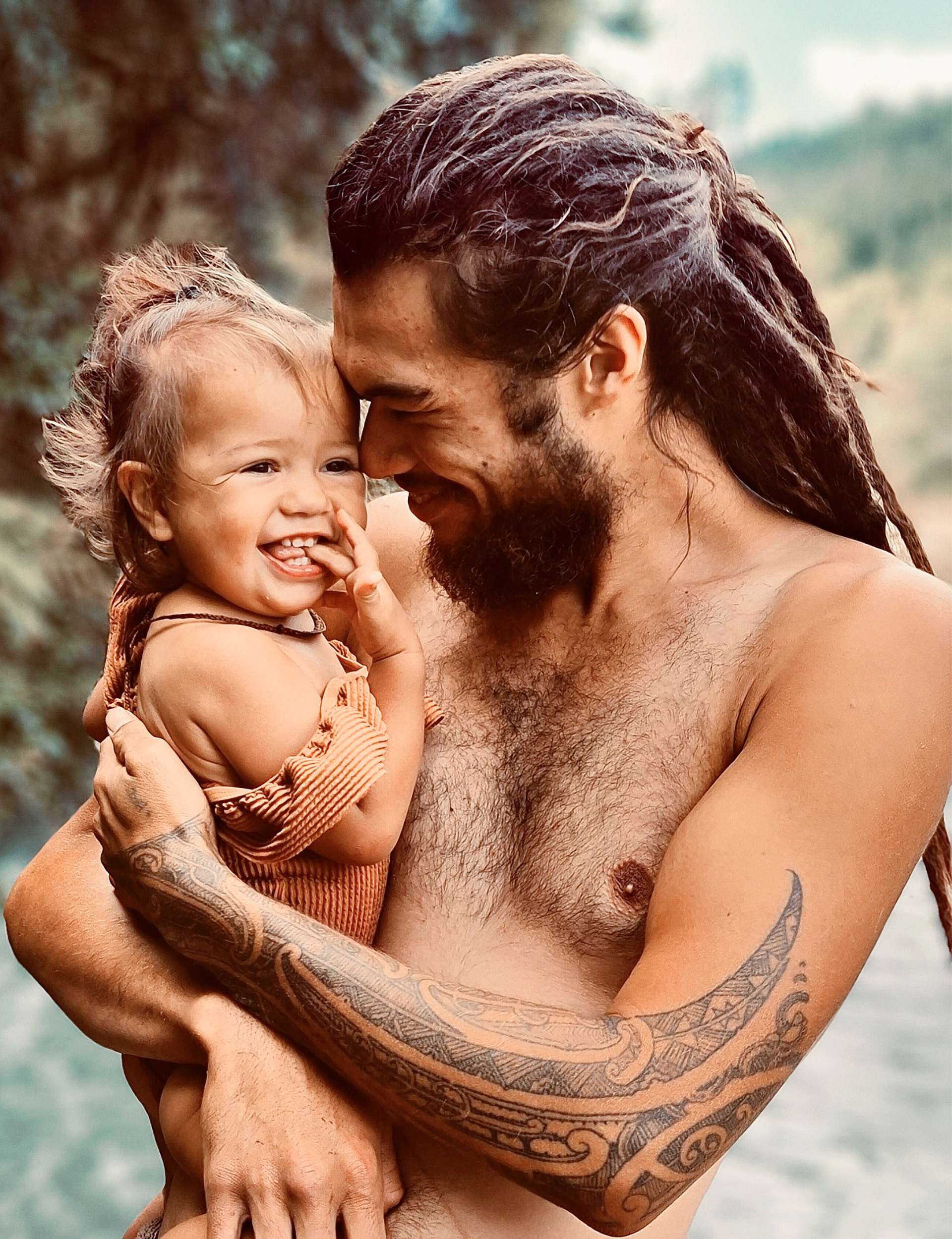 Jasmine&rsquo;s husband Pineamine holding  their daughter while standing in a river