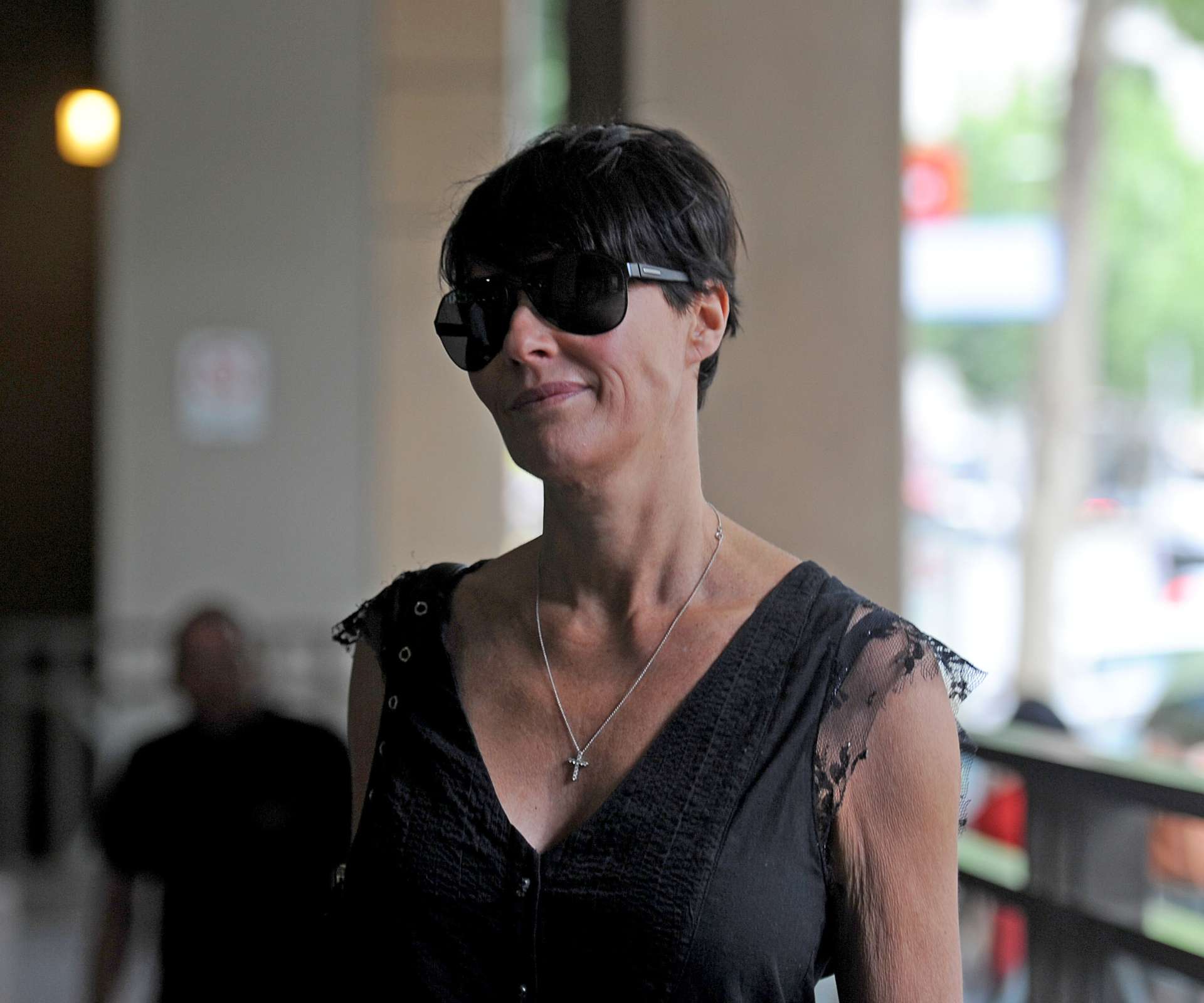 A woman smiling wearing sunglasses