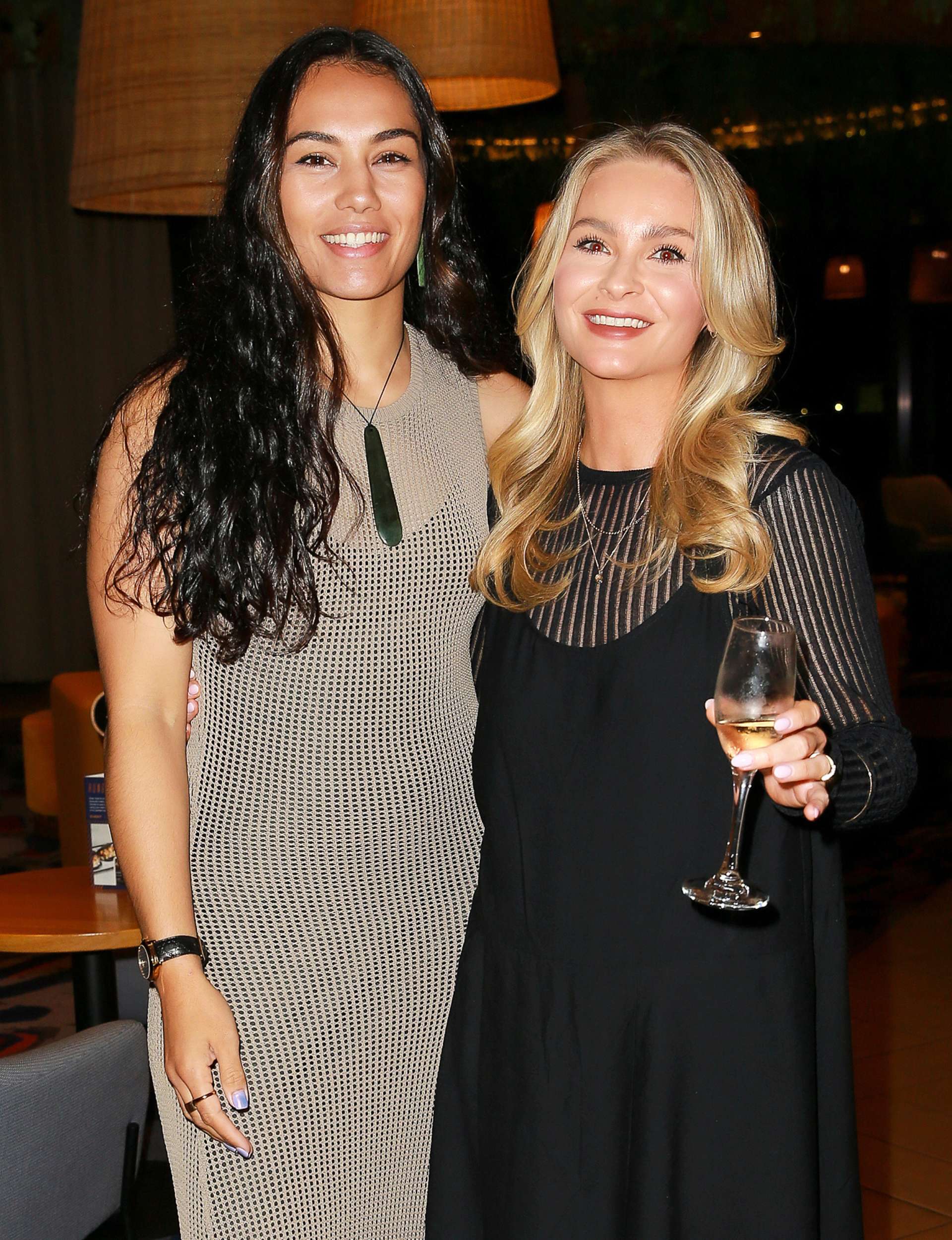 Janay Harding with her arm around Brittany Cunningham, who's holding a champagne flute