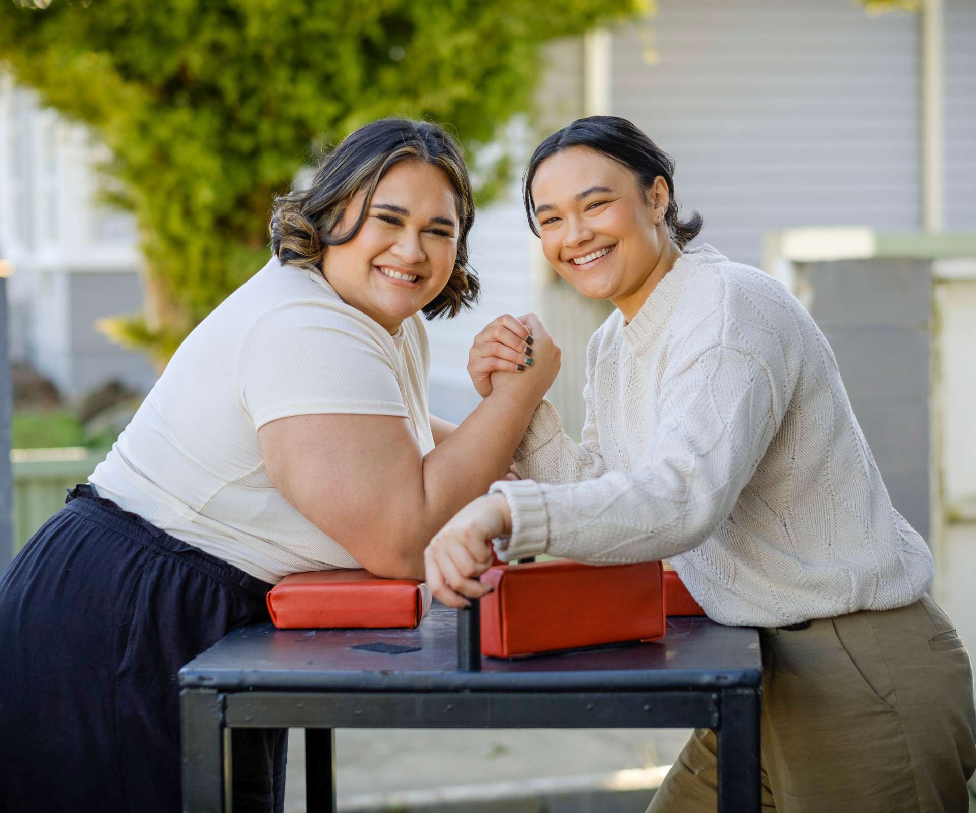 Dariah and Ashleigh in position ready for an arm wrestle at the table