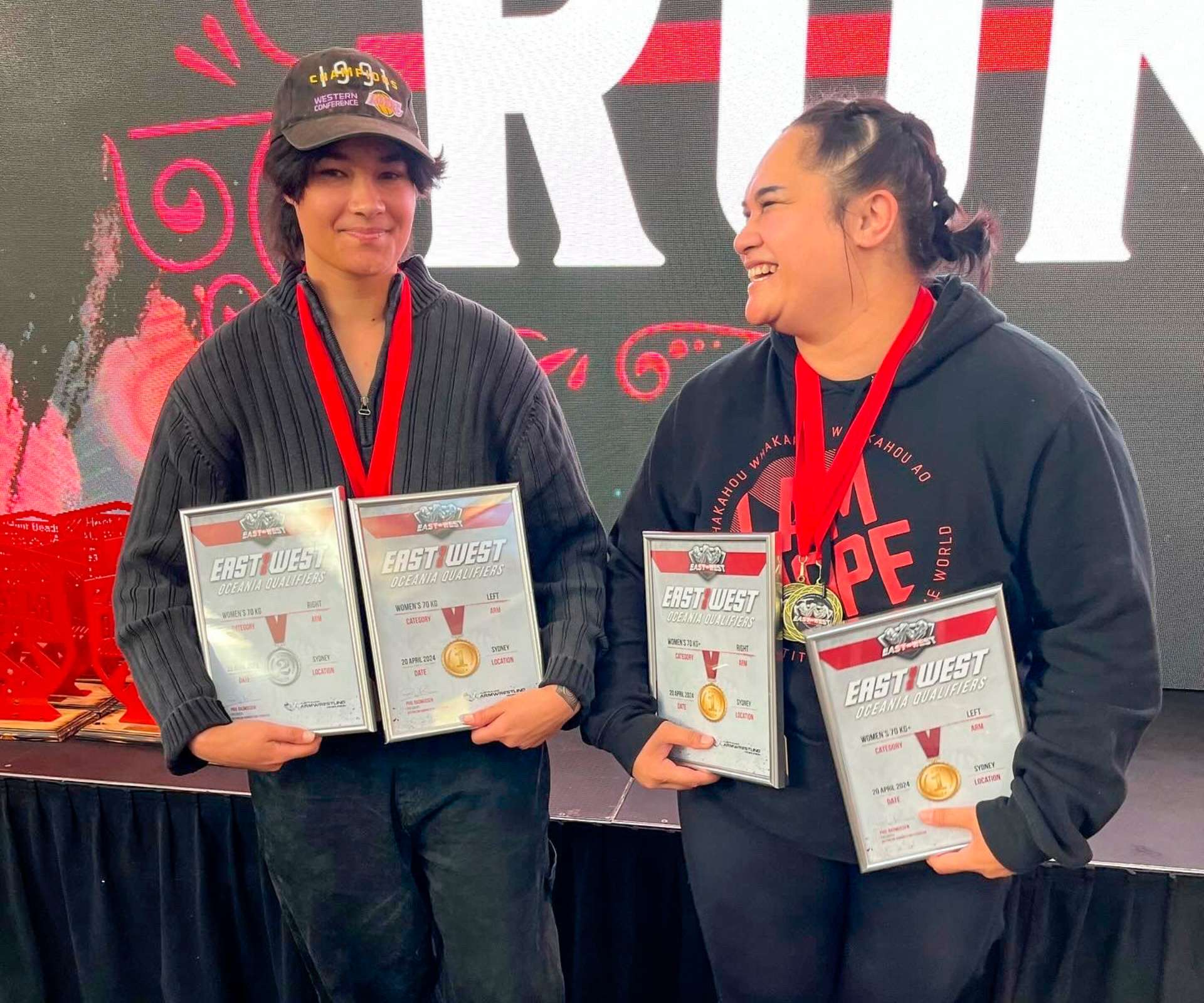 Dariah and Ashleigh holding up their first place certificates with big smiles