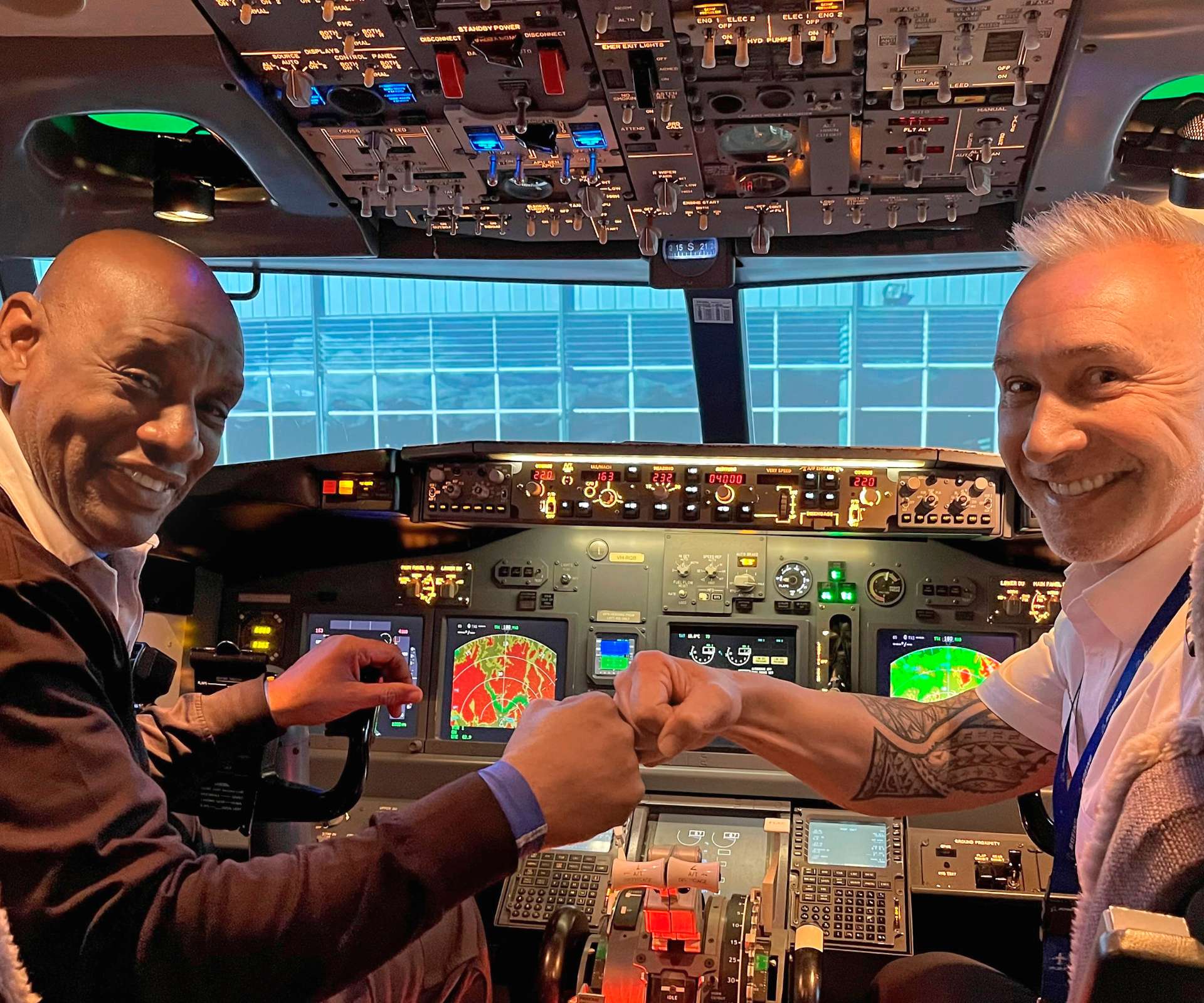 Shaun giving Mike Pero a fist bump in the cockpit of a plane