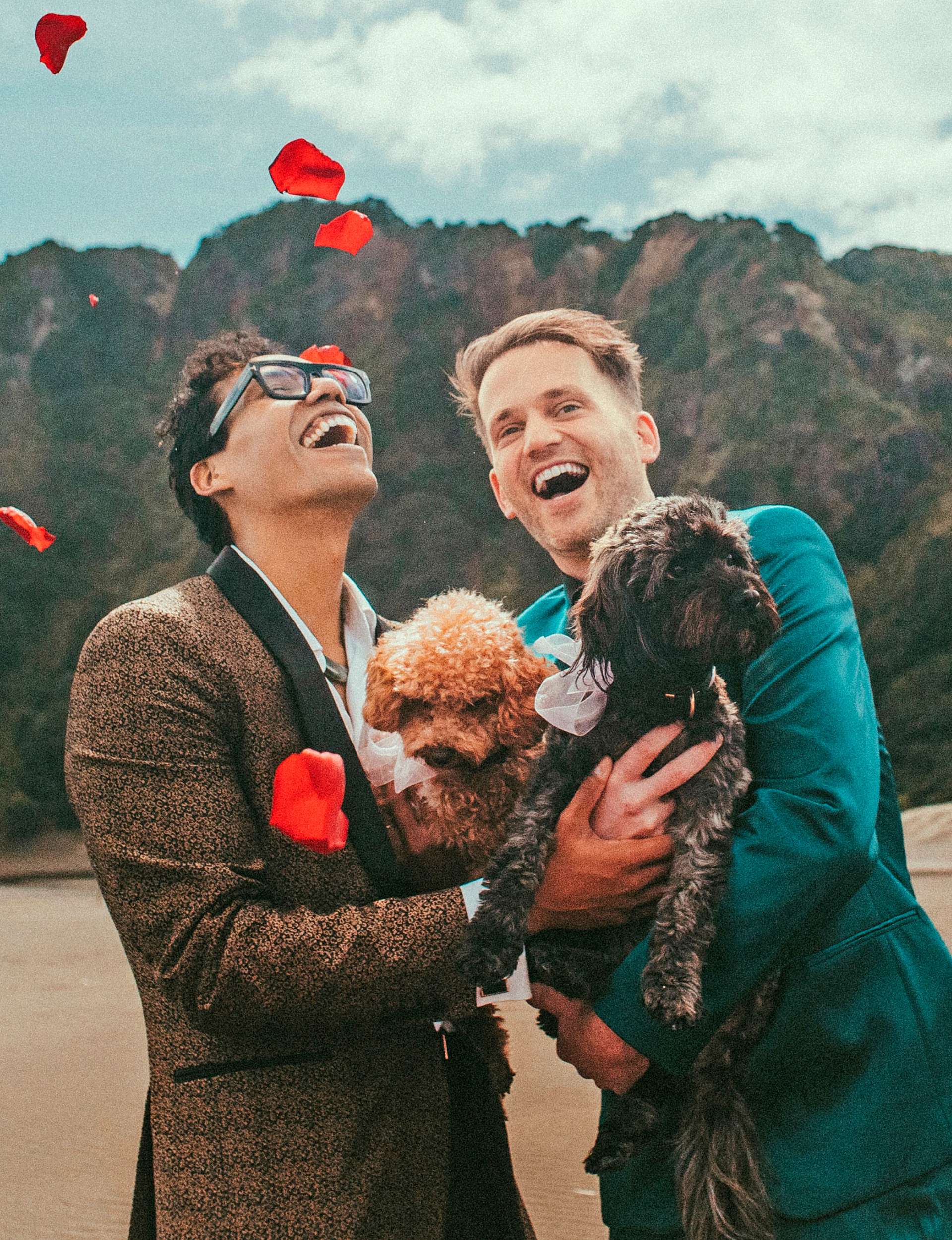 Andrew and Esa&uacute; holding puppies on their wedding day
