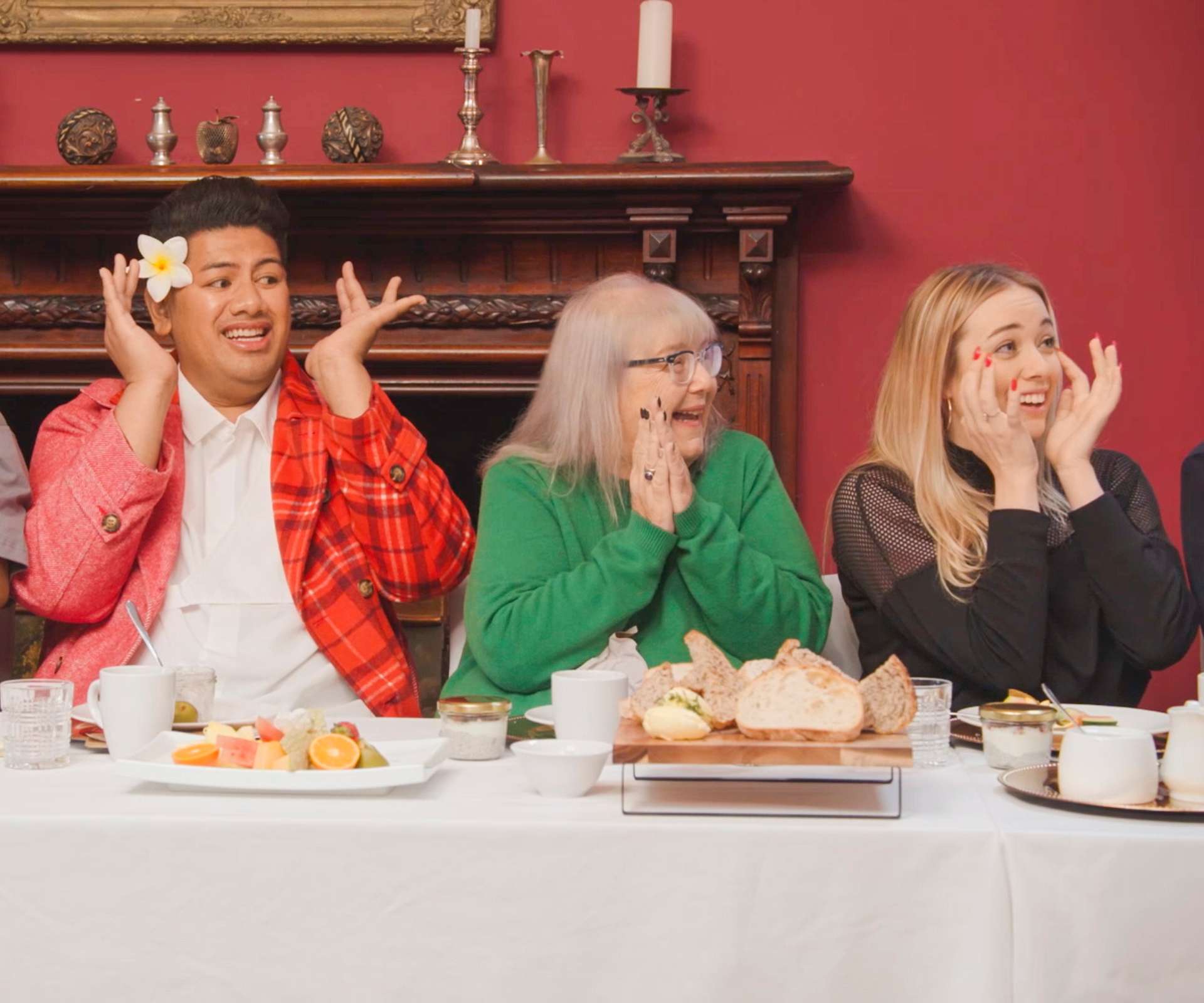 Jackie at the dinner table reacting to a surprise with fellow Traitors contestants