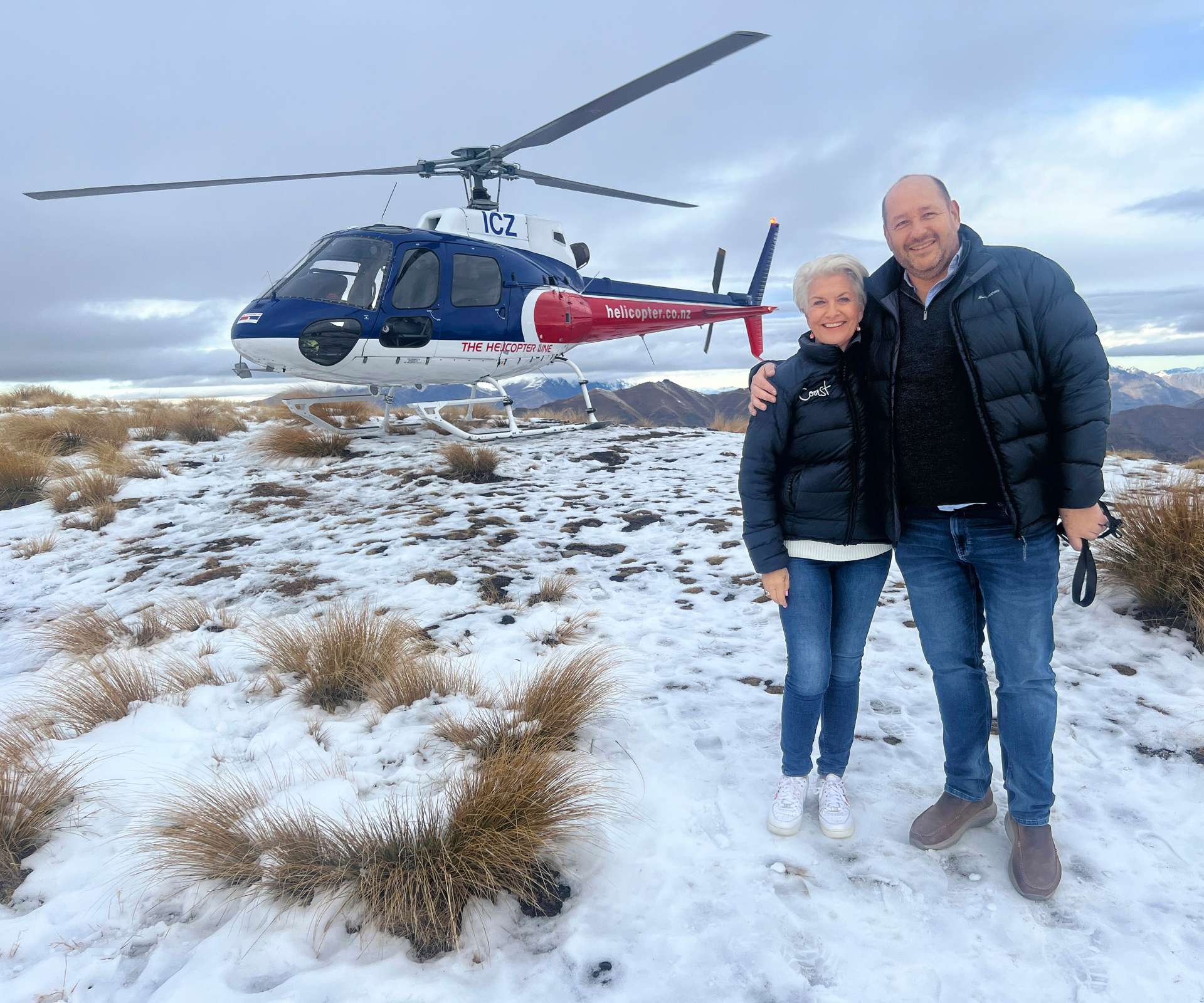 Lorna and Mike in front of a helicopter in Queenstown