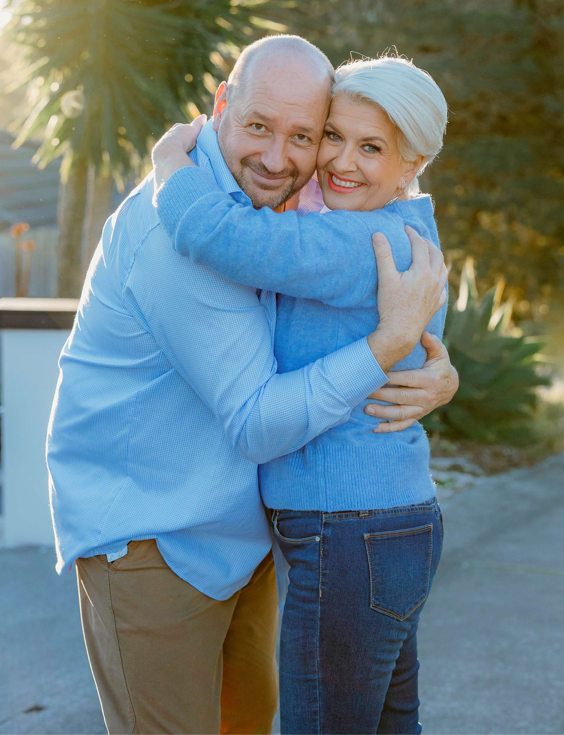 The couple hugging and looking at the camera