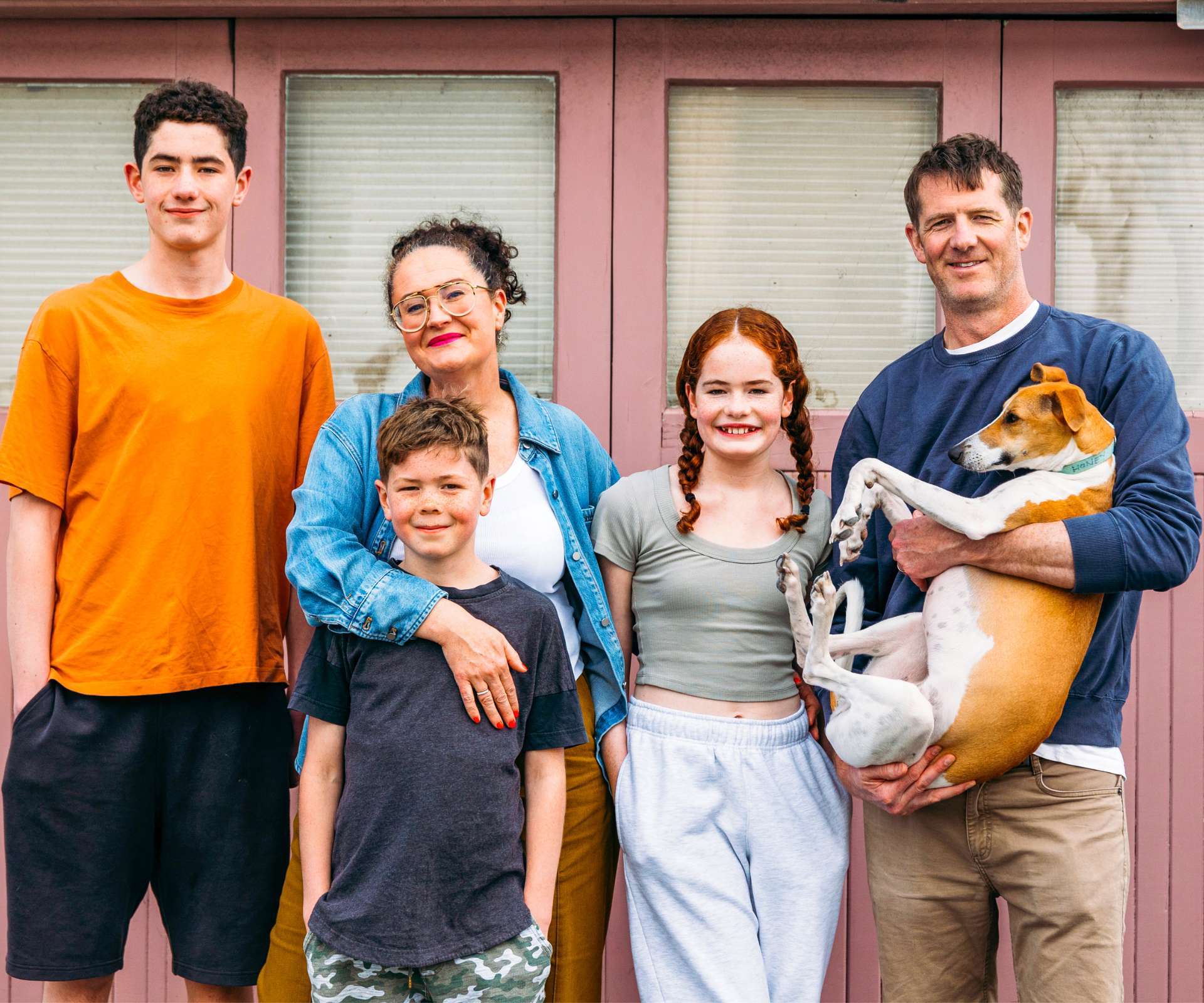 Standing in front of pink doors with her family