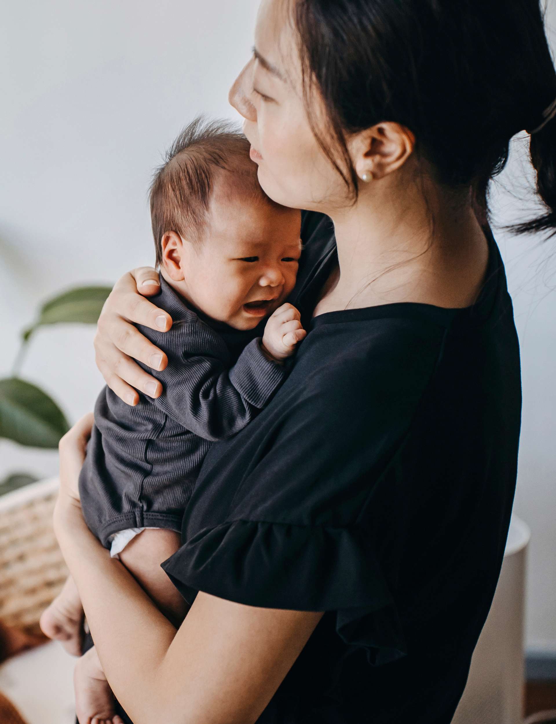 A woman holding her crying baby who has whooping cough