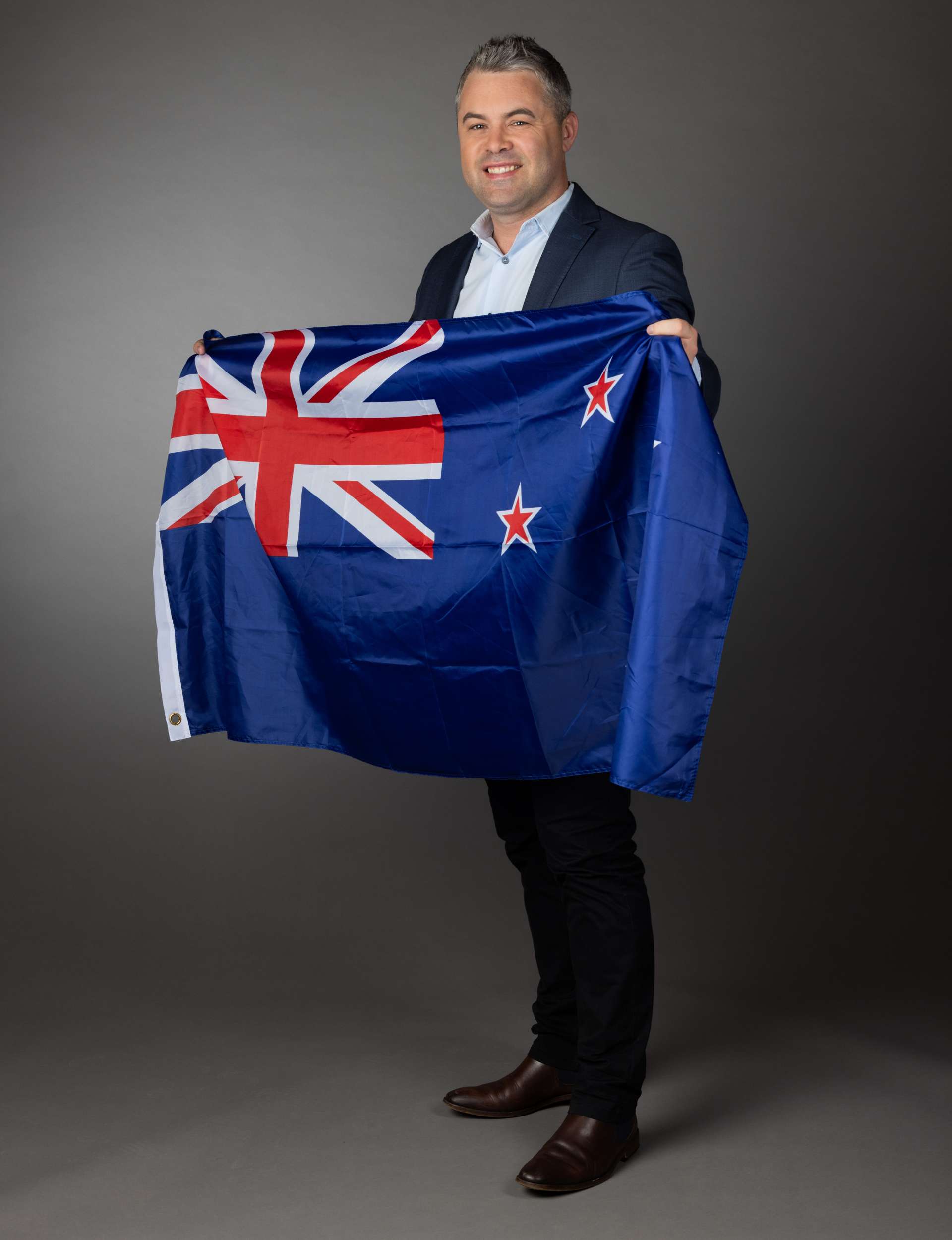 Sky Sport presenter Jeff McTainsh holding a New Zealand flag before the Olympics