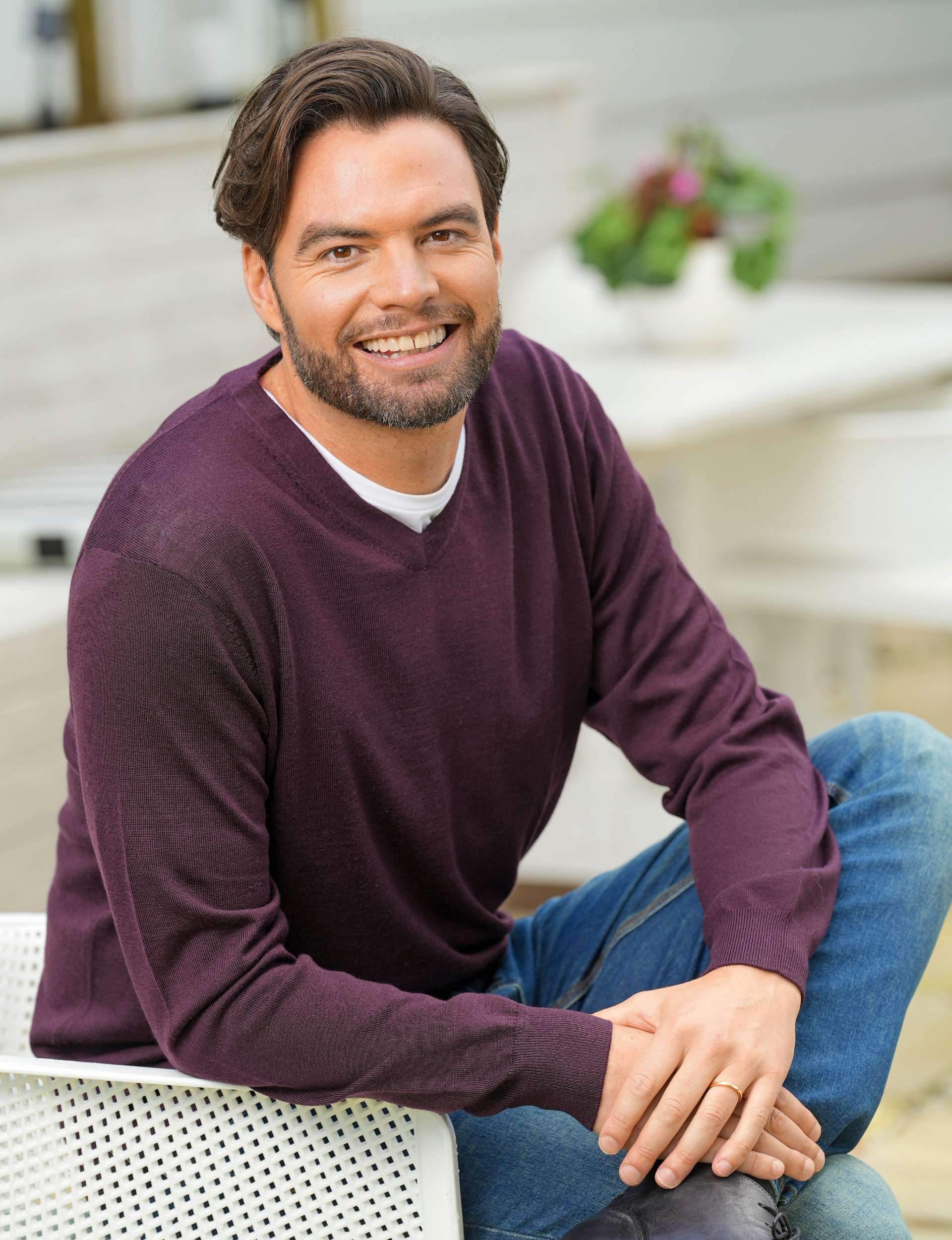Ryan Bridge smiling in a maroon sweatshirt