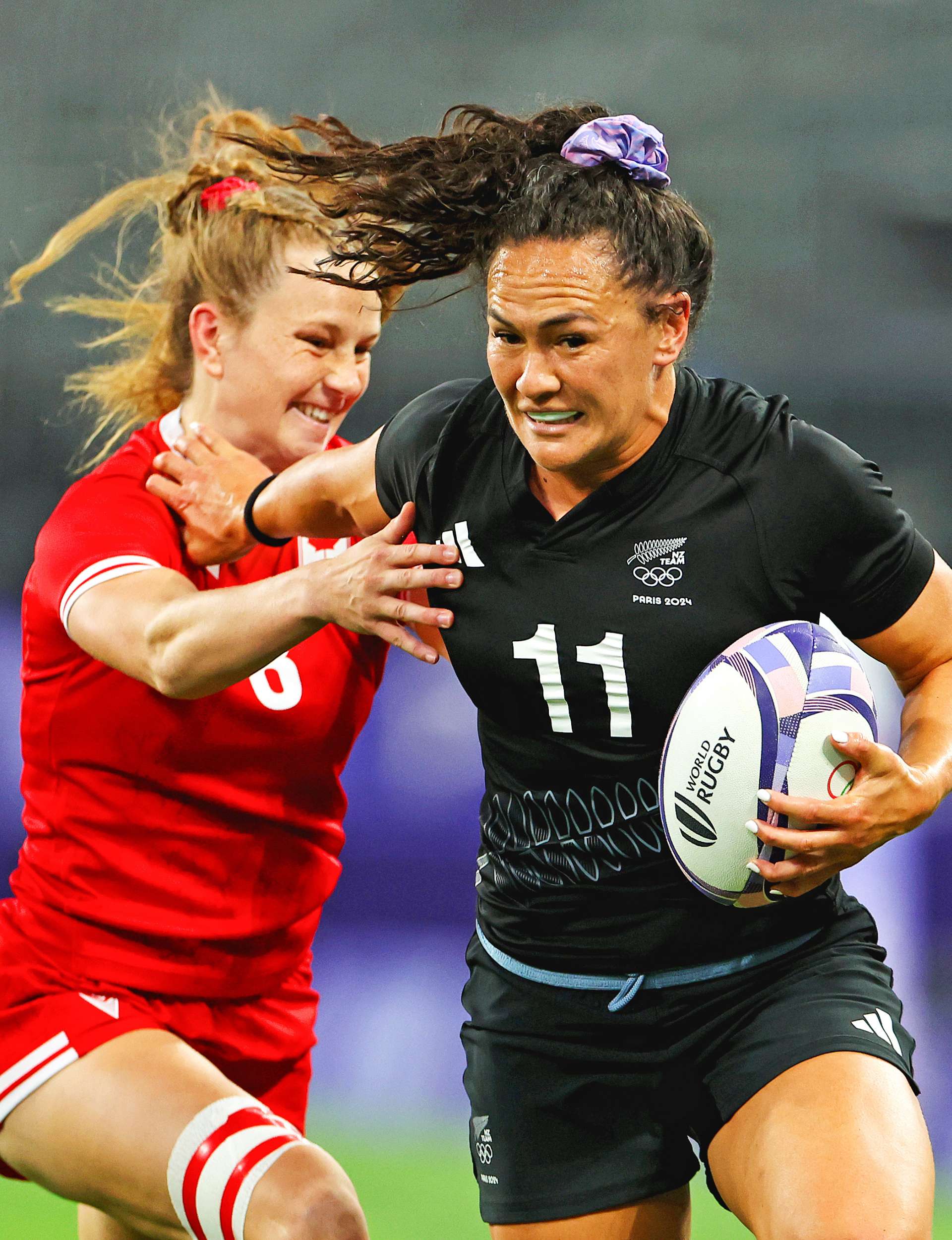 Portia Woodman-Wickliffe fending off a Canadian player