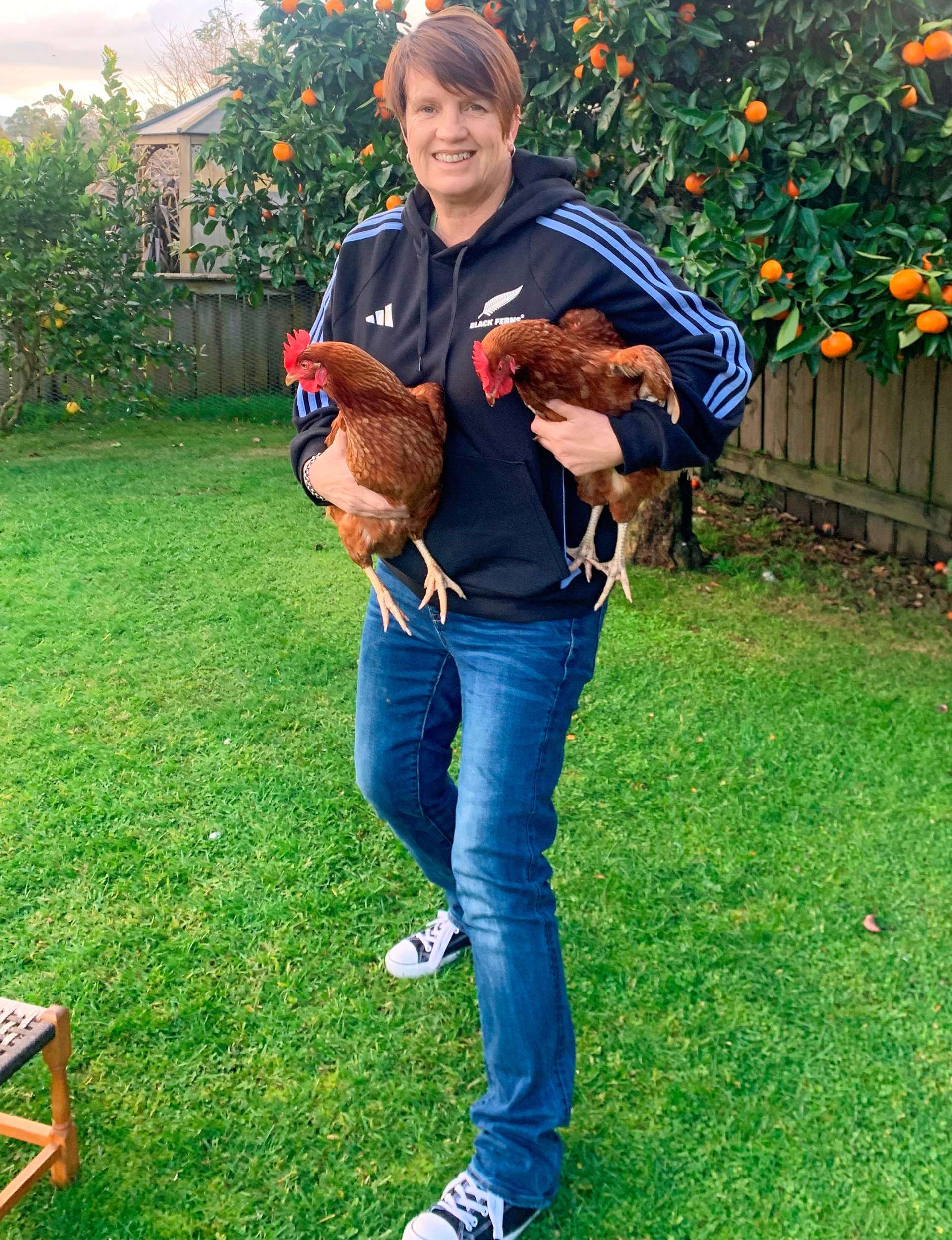 Jane holding her chickens under each arm
