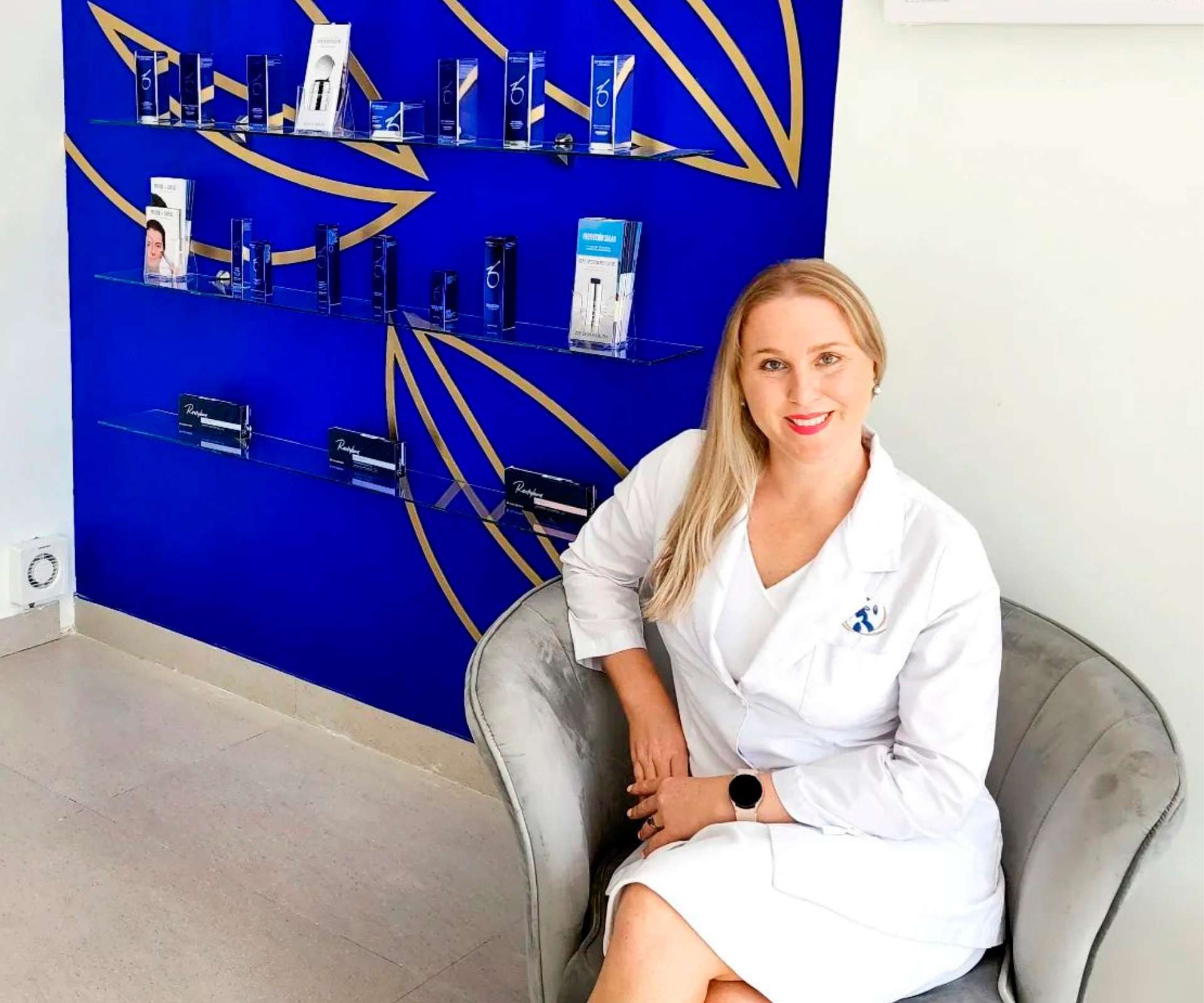 Lonneke sitting in a chair in the reception space of her beauty clinic