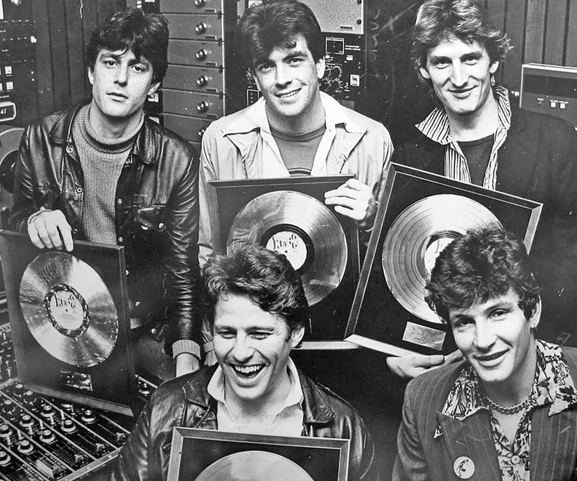 Moana's dad's band, Hello Sailor holding up records of their music