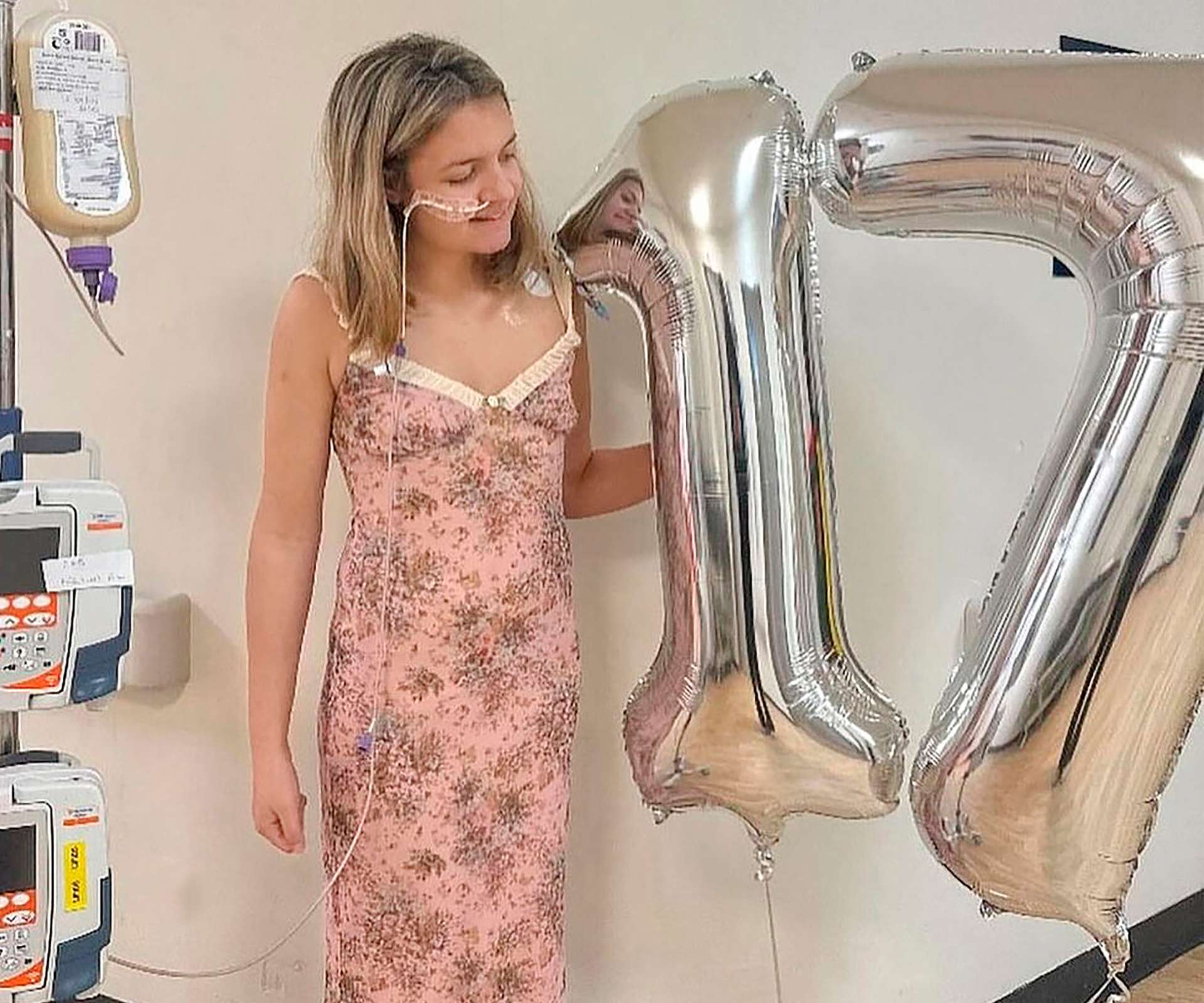 Eva Mitchell standing beside silver helium '17' balloons