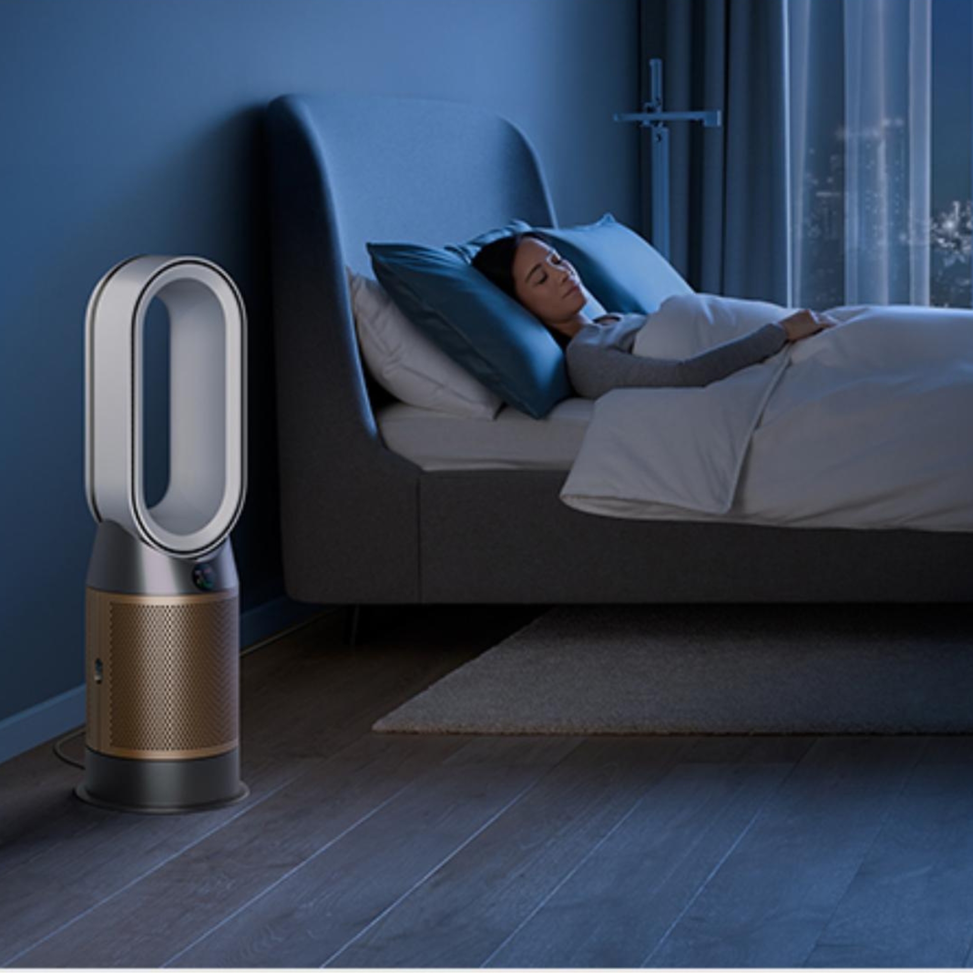 A woman sleeping in bed next to the Dyson Purifier 