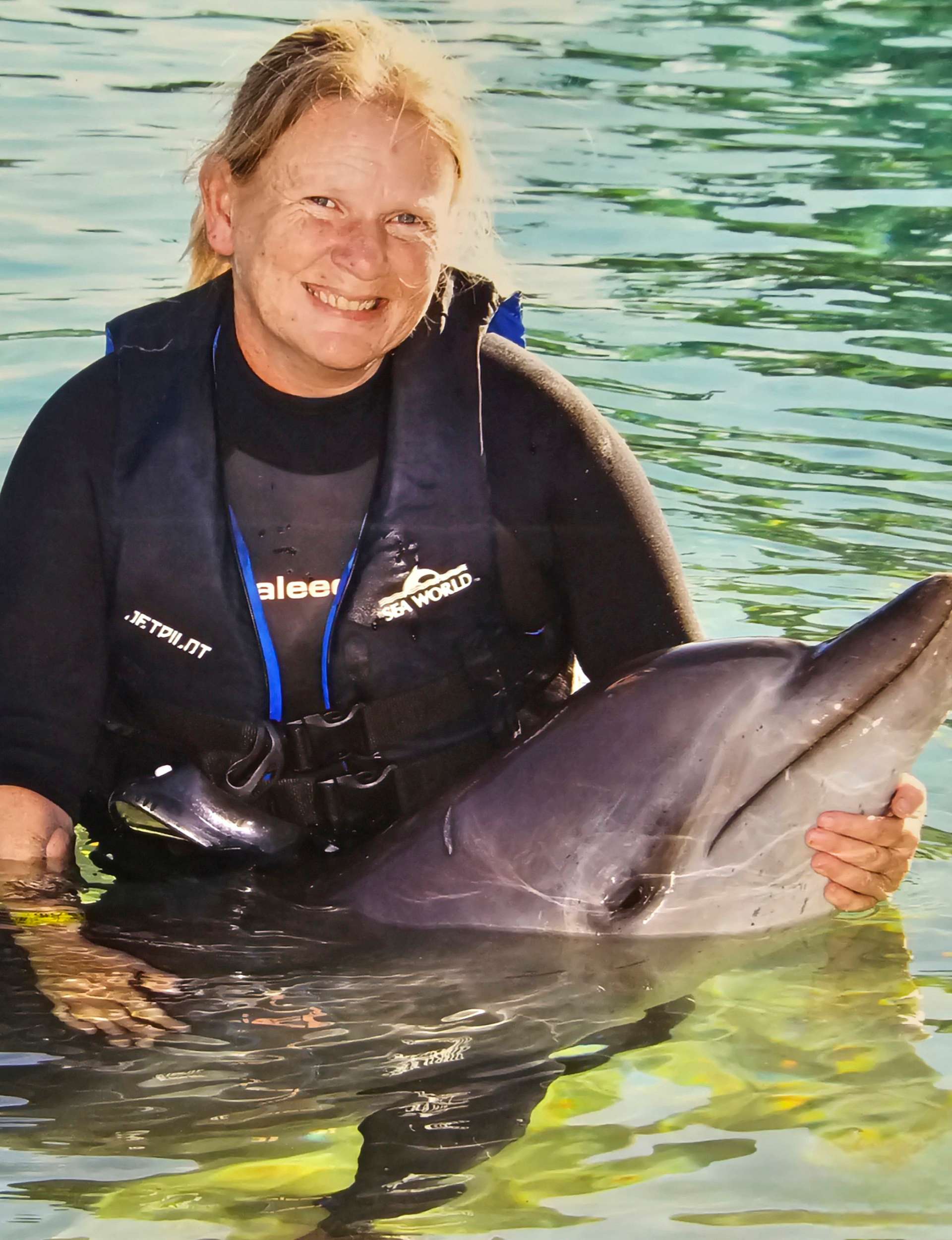 Karen Barnett holding a dolphin at Sea World