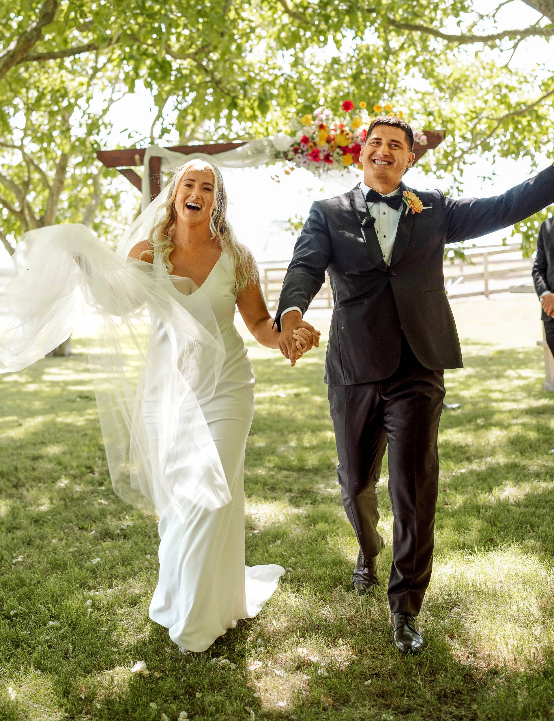 Grace and Rameka celebrating as they leave their wedding ceremony