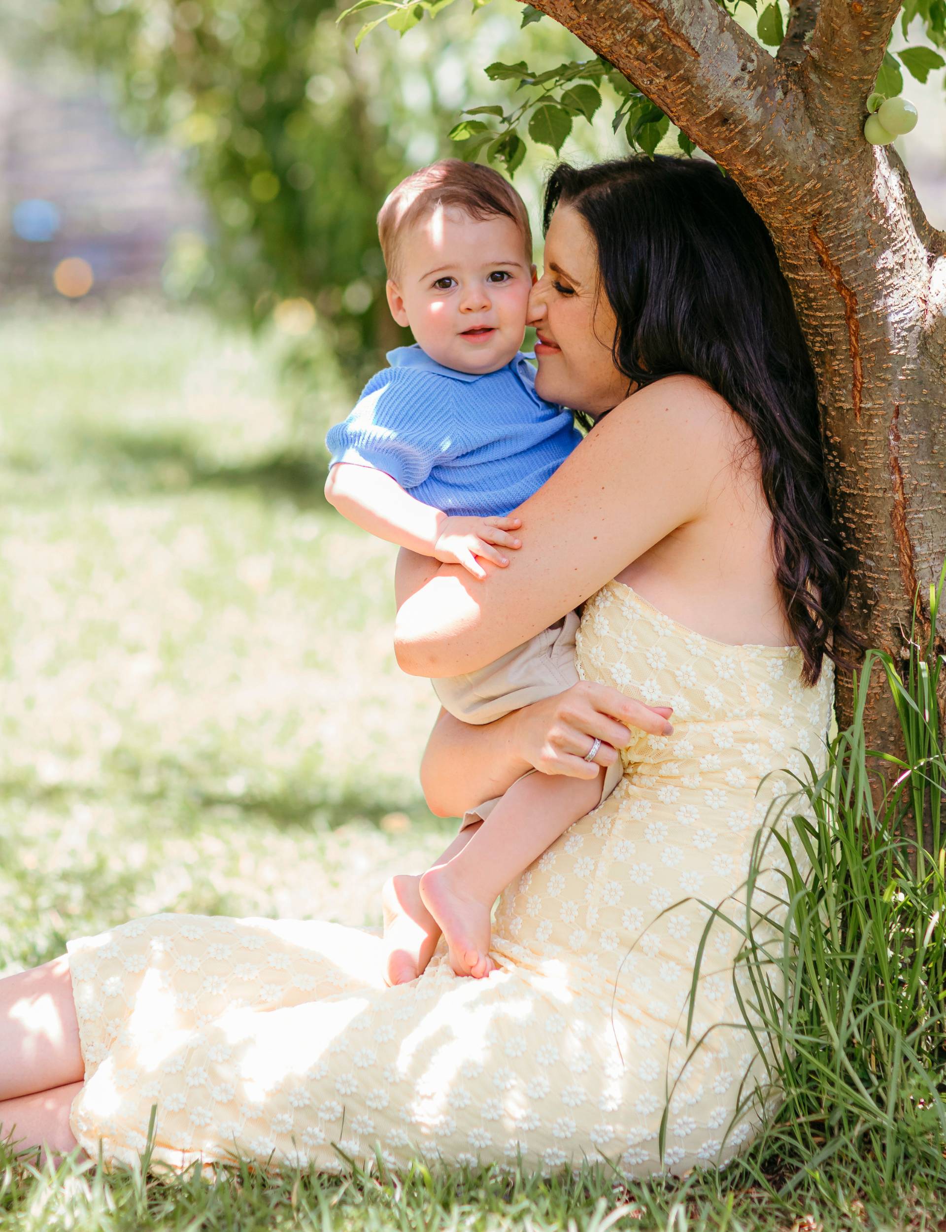 Cuddling baby Frankie while sitting at the base of a tree