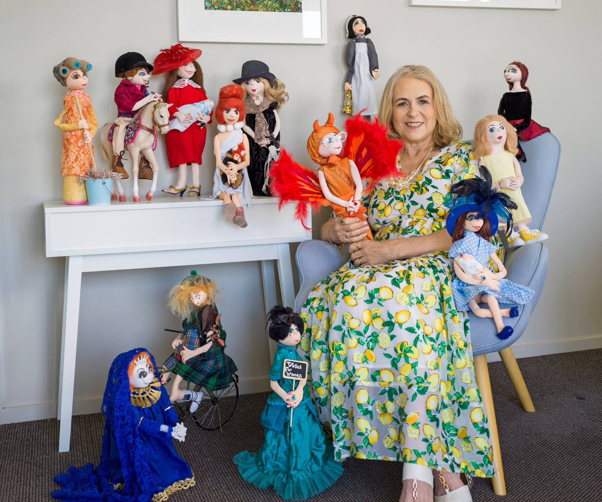 Jill sitting at a desk covered in her dolls