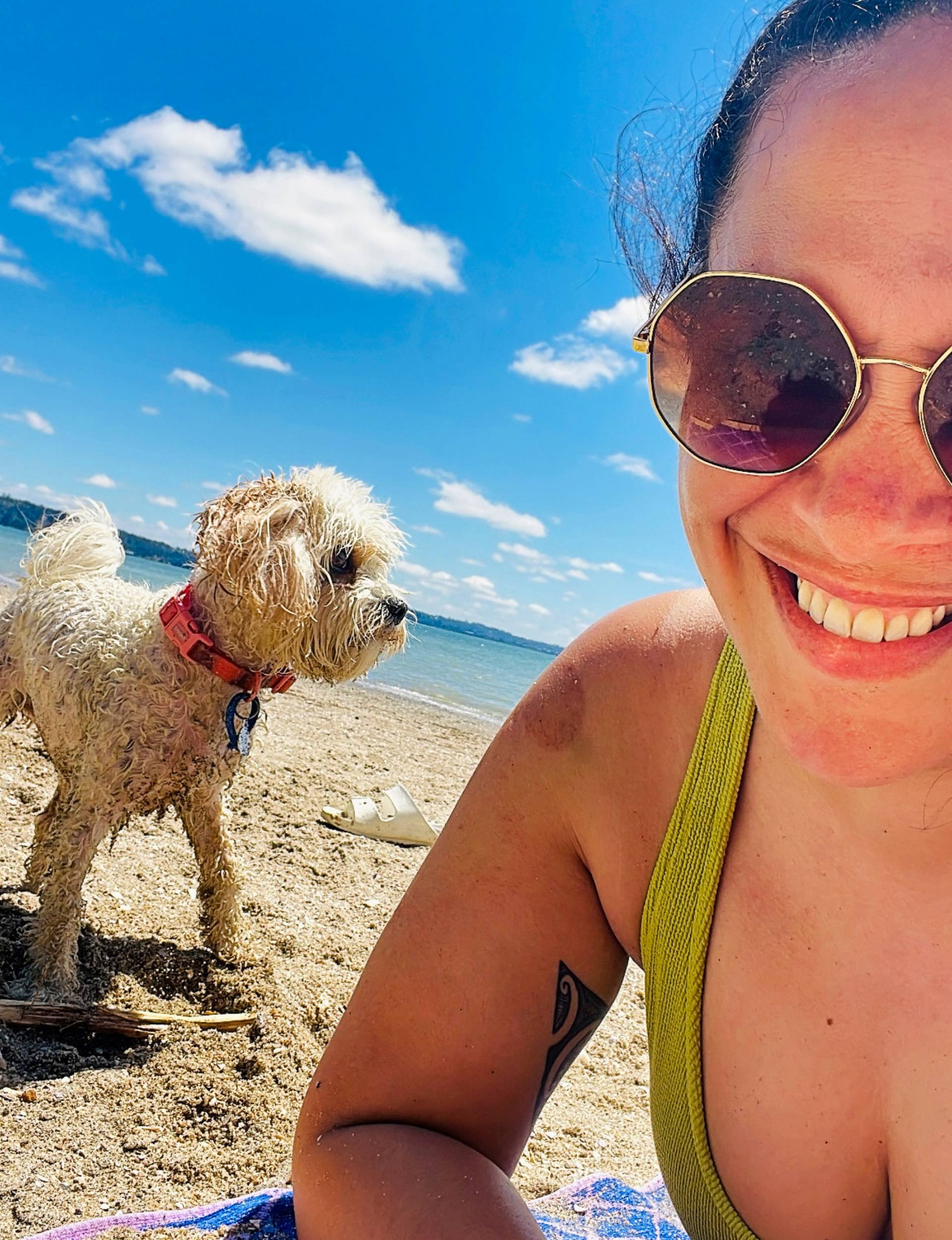 Kura on a beach with her dog in summer