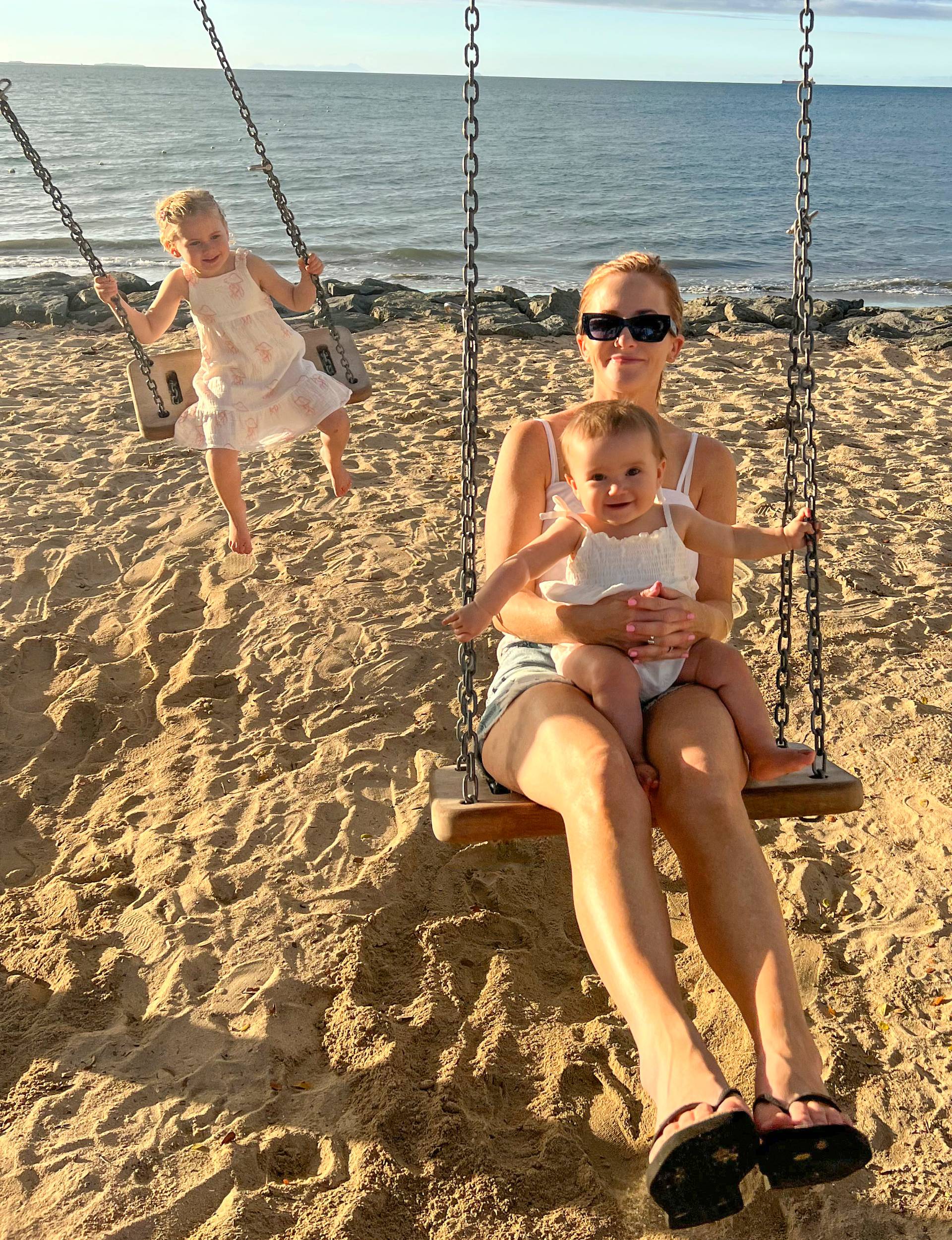 Lee and the couple's daughters on swings