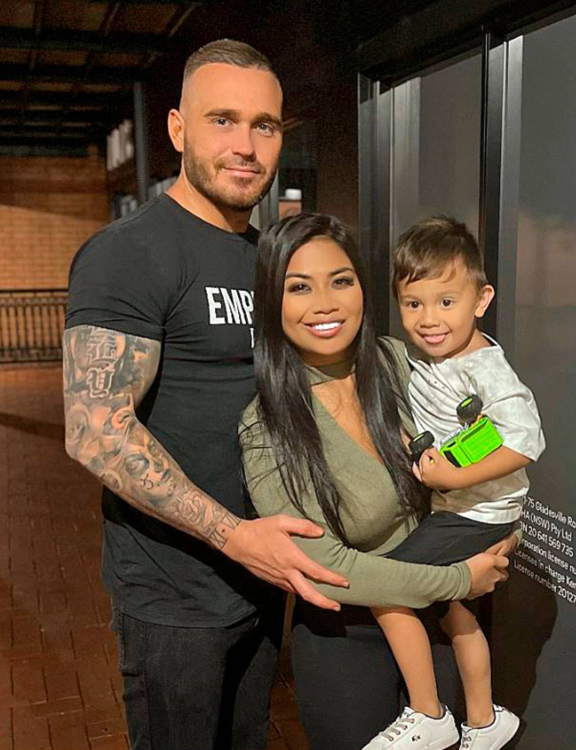 Cyrell standing in front of Eden holding their son Boston