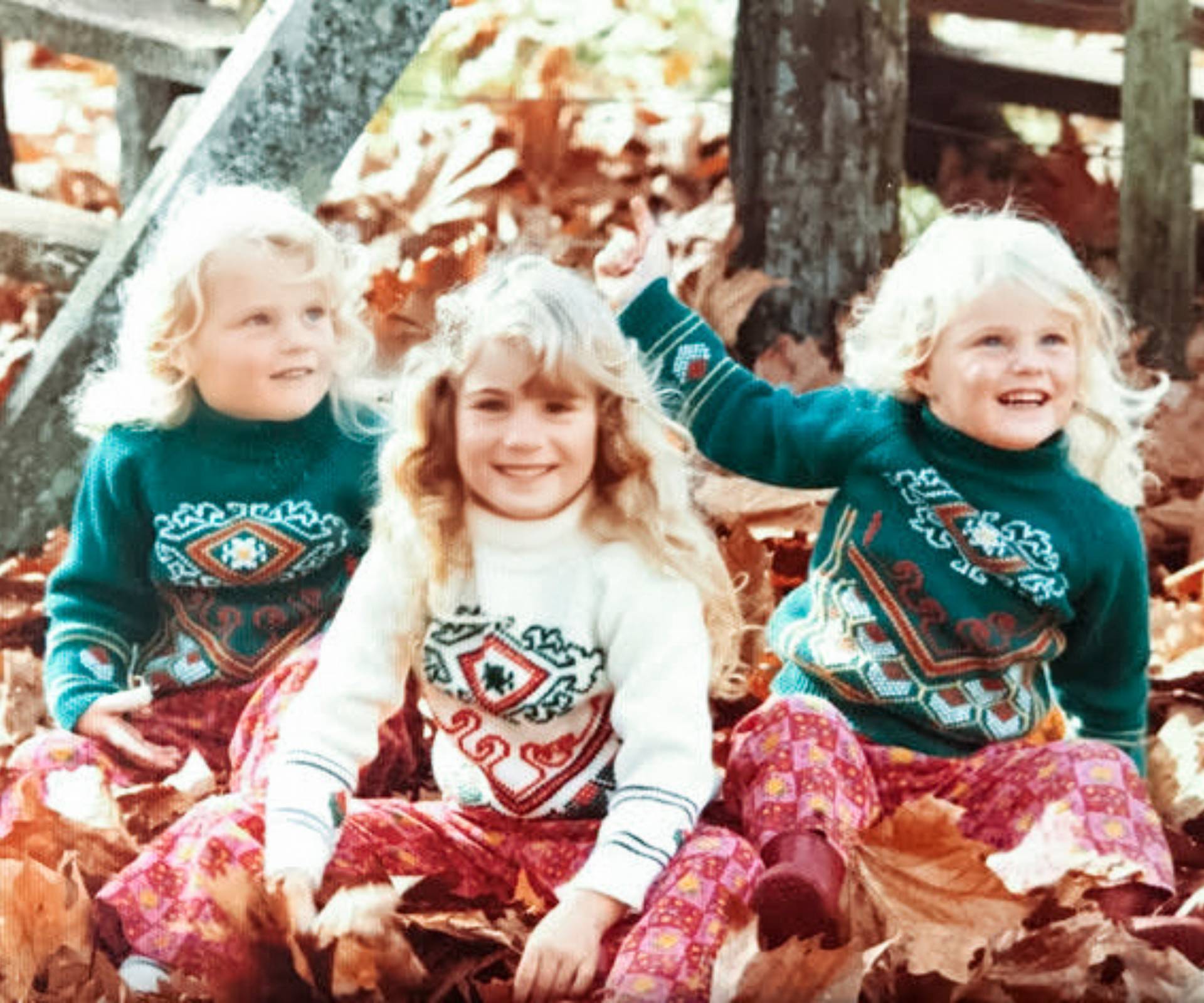 Julia's kids playing in a pile of autumnal leaves