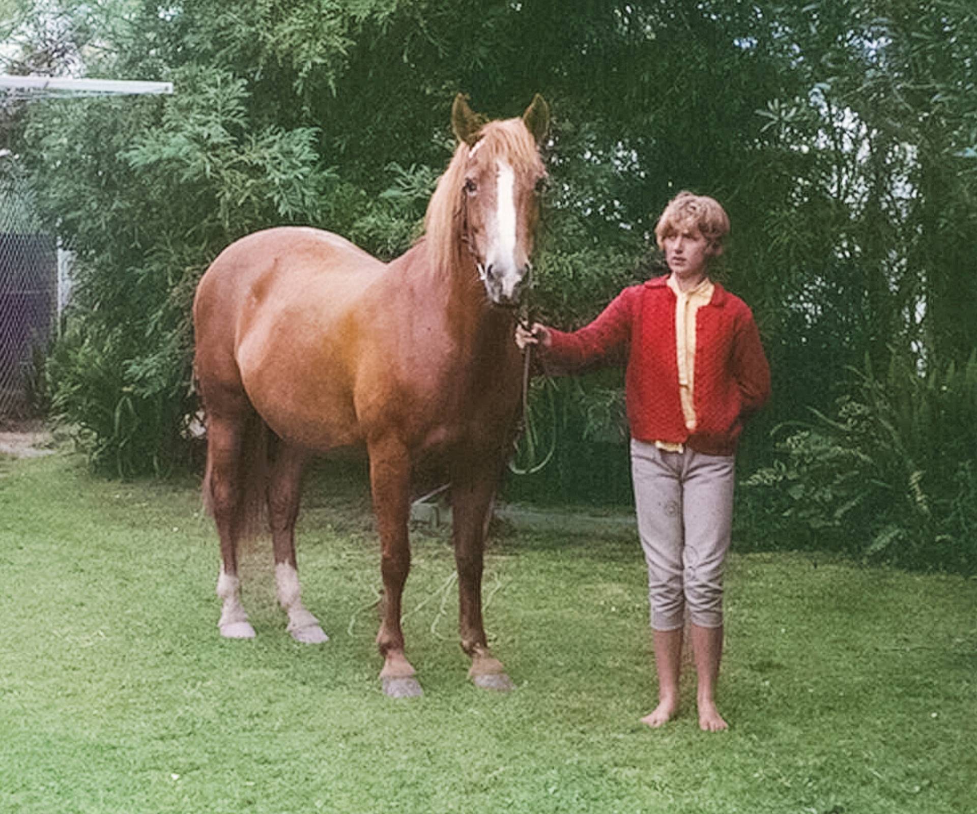 Julia Hartley Moore holding the reins of her horse as a young adult