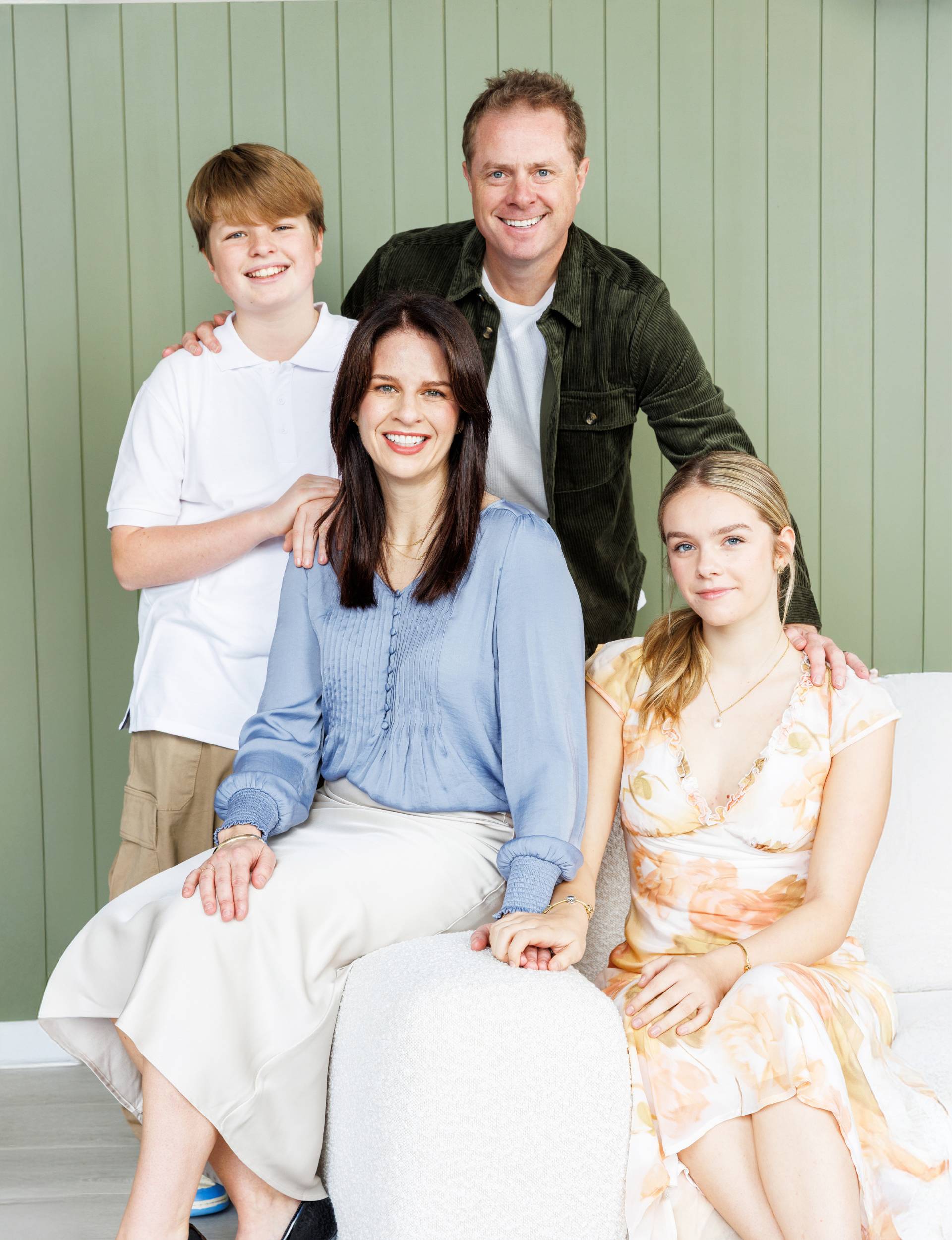 Erica Poppelbaum with her family in front of a green wall
