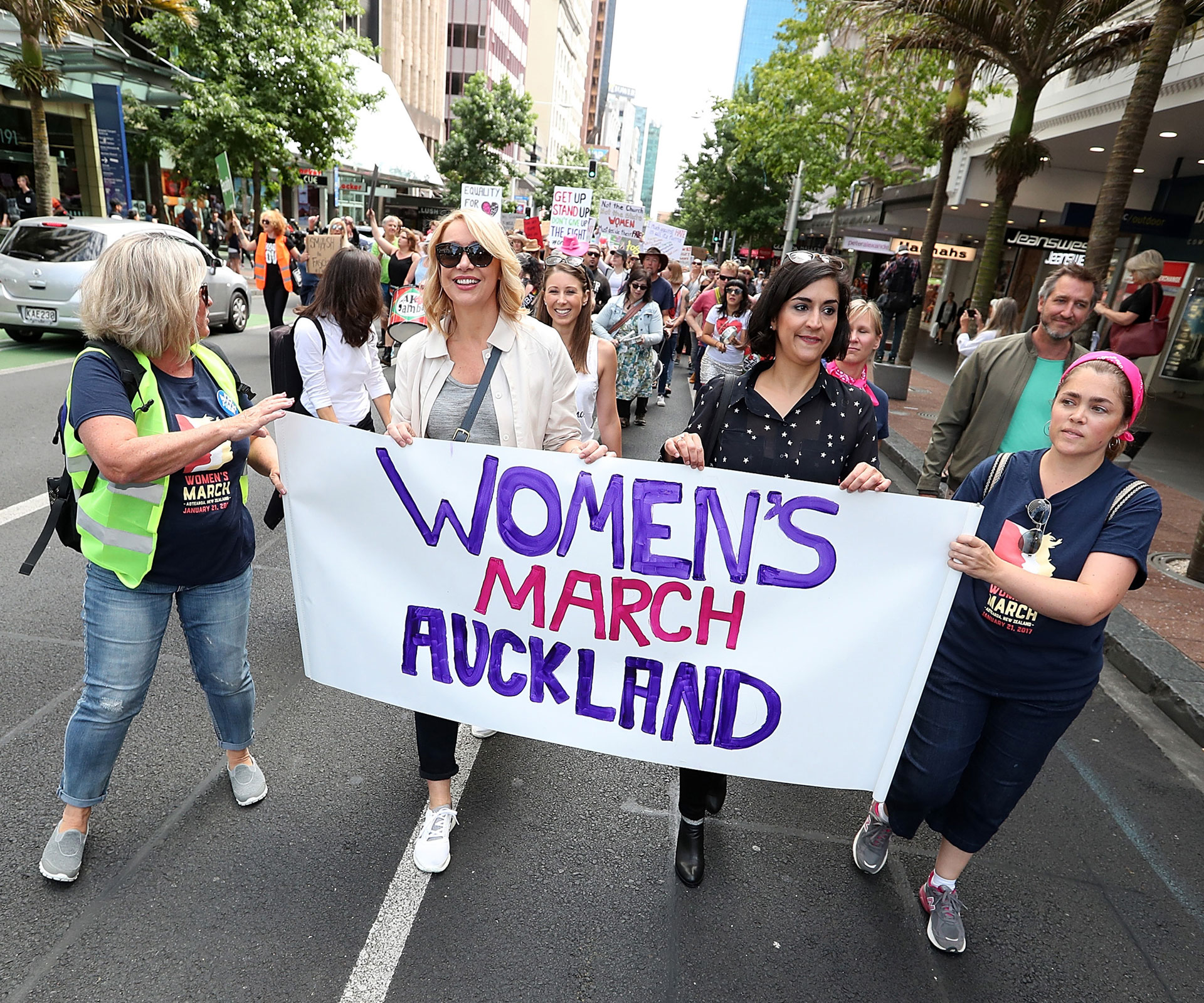 Lizzie Marvelly (in white sleeveless top) walks behind broadcaster Ali Mau (at front in sunglasses) along Auckland’s Queen Street on January 21, in a global show of solidarity with those marching in Washington DC. 