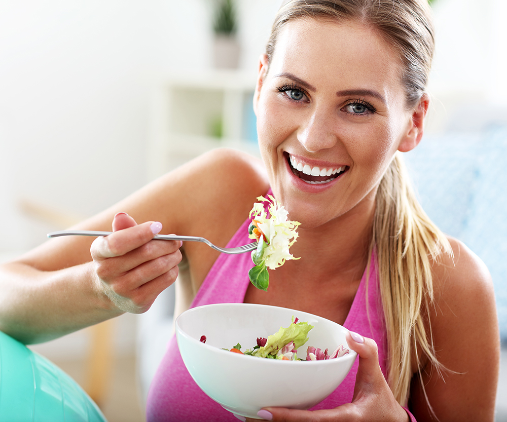 blonde woman eating salad
