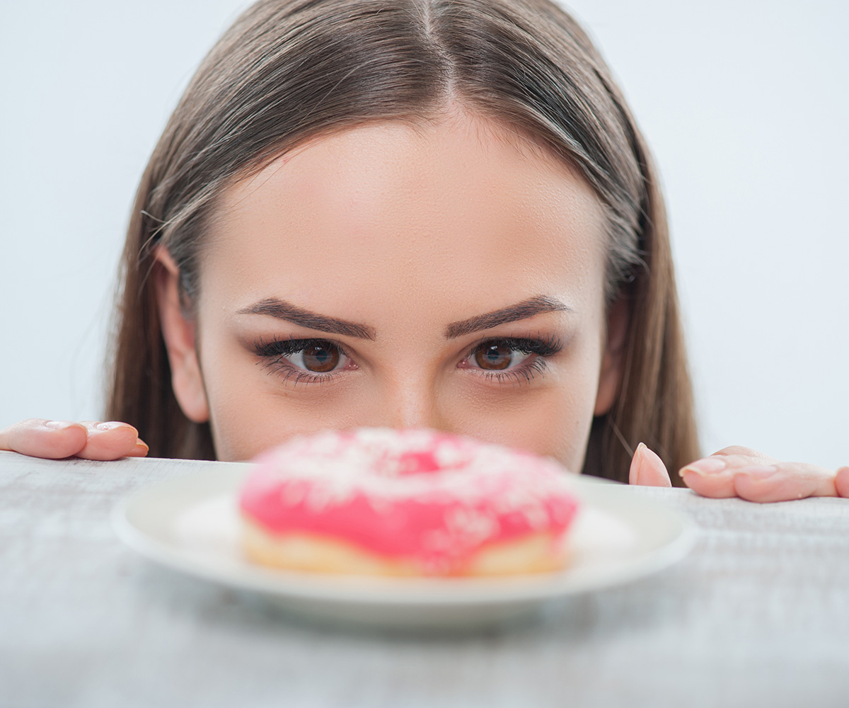woman staring at a pink donut