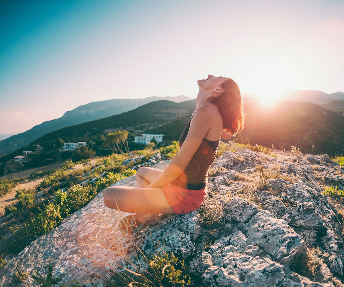 woman sitting on a mountain sun spot
