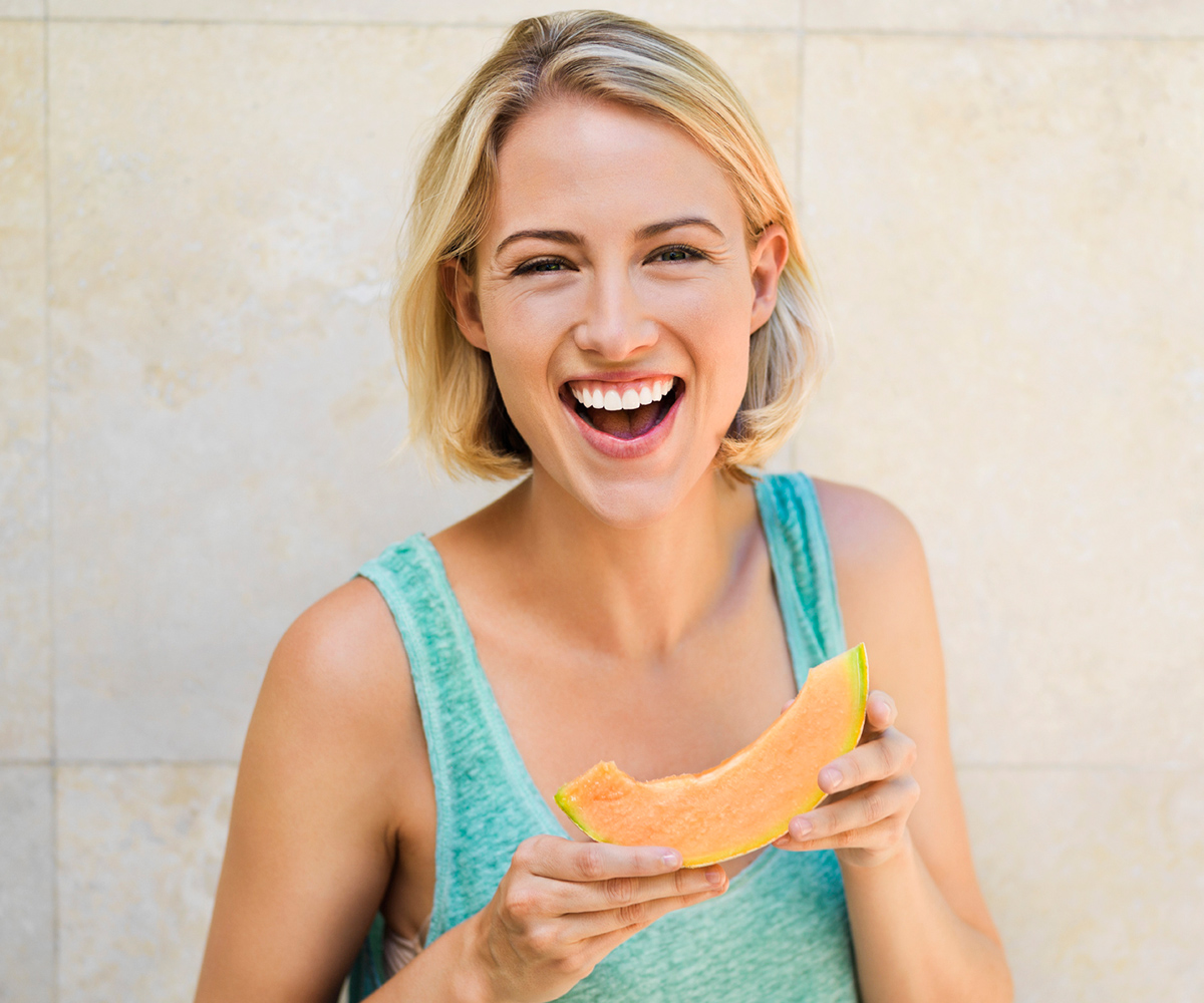 smiling woman eating melon